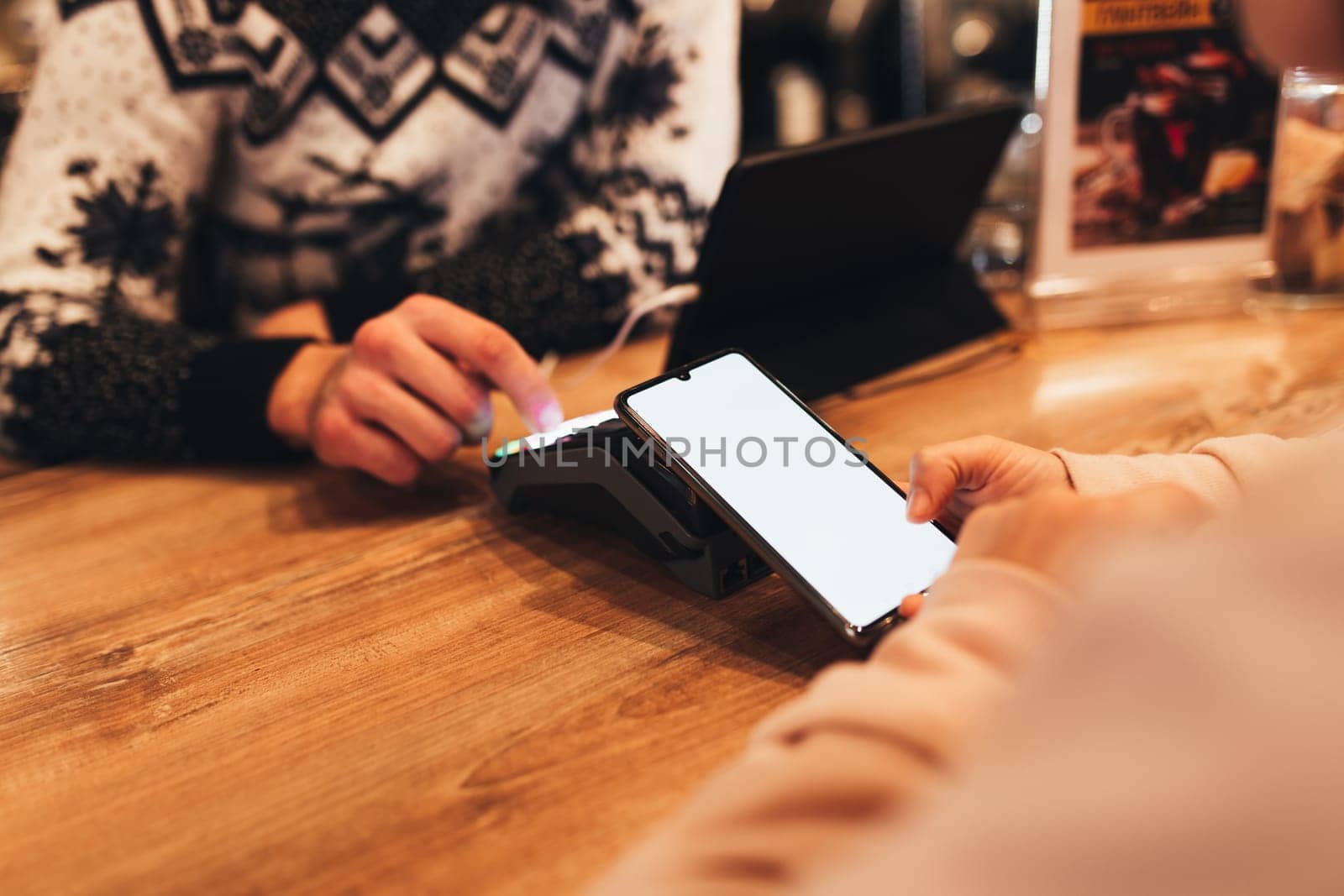 Cashless payment with NFC and phone in a cafe terminal. Blurred background. High quality photo