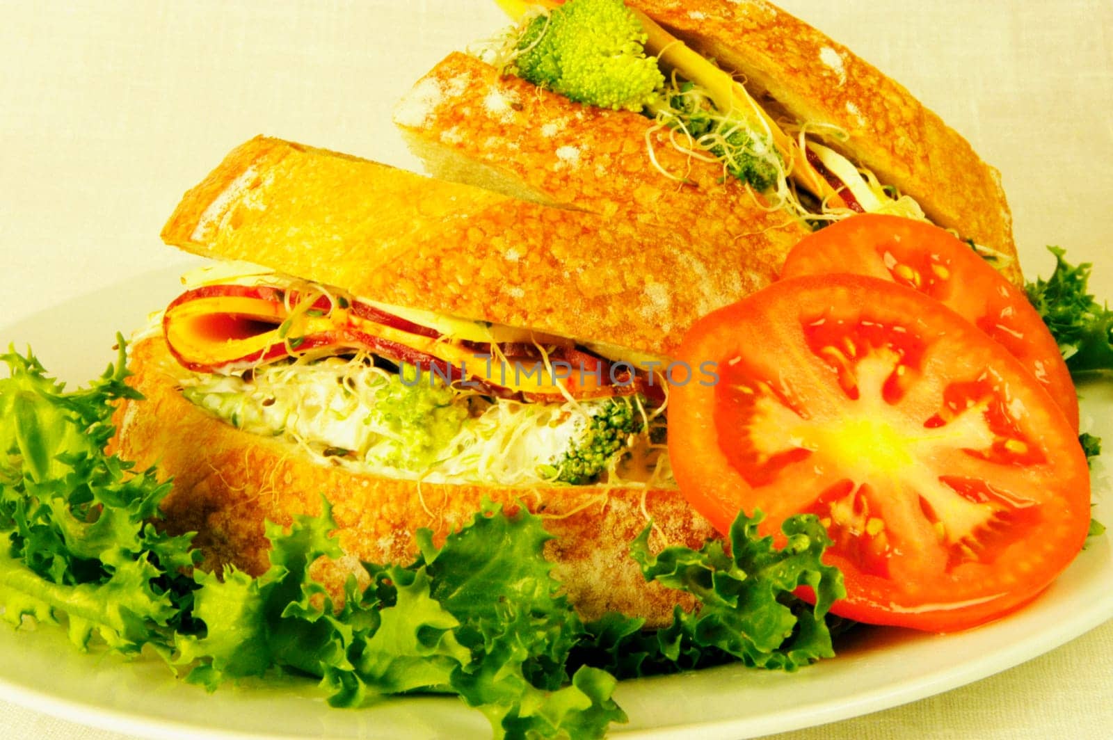 Close-up of tomato slices with sandwiches on a plate