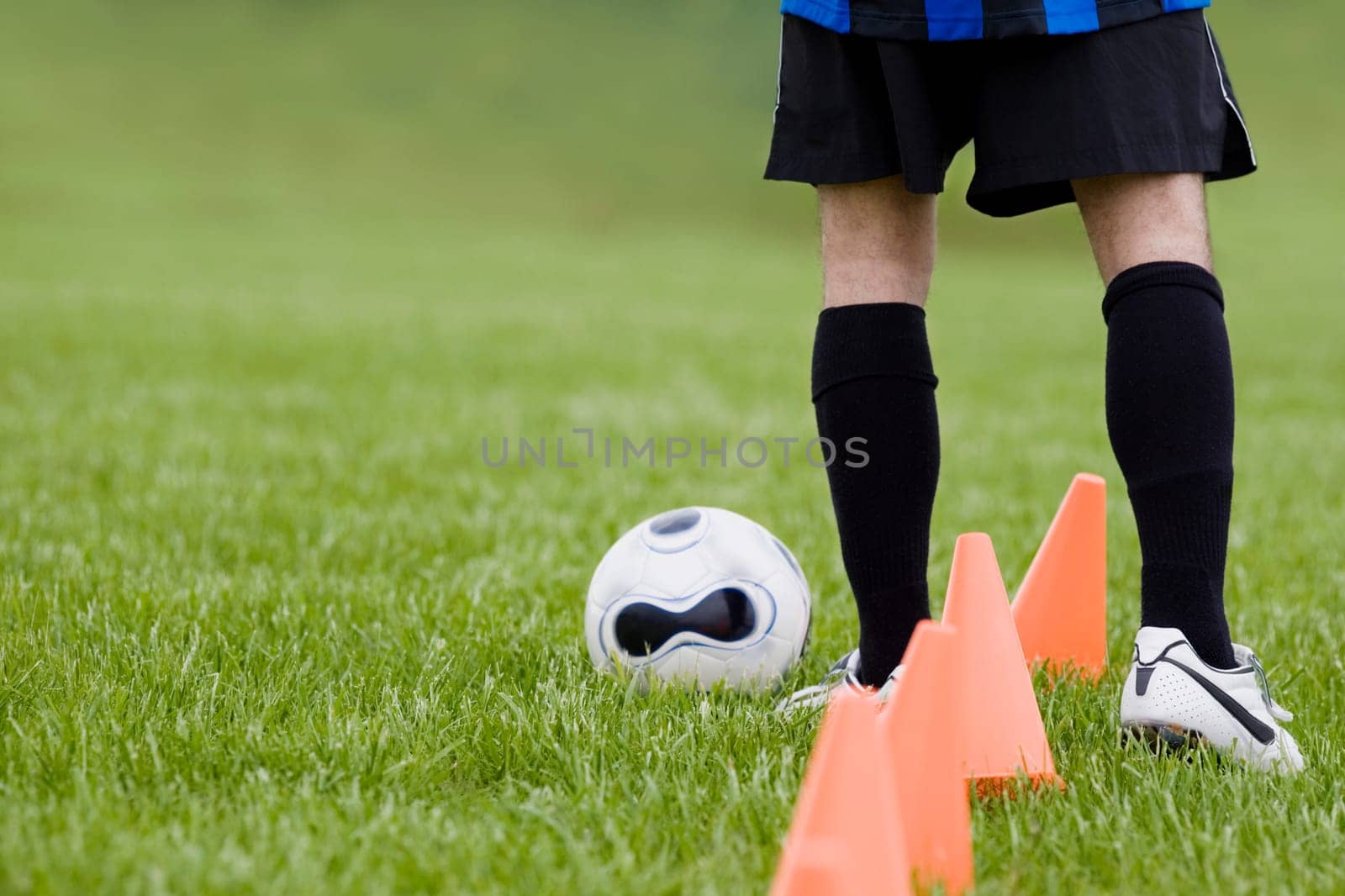 Low section view of a soccer player practicing dribbling