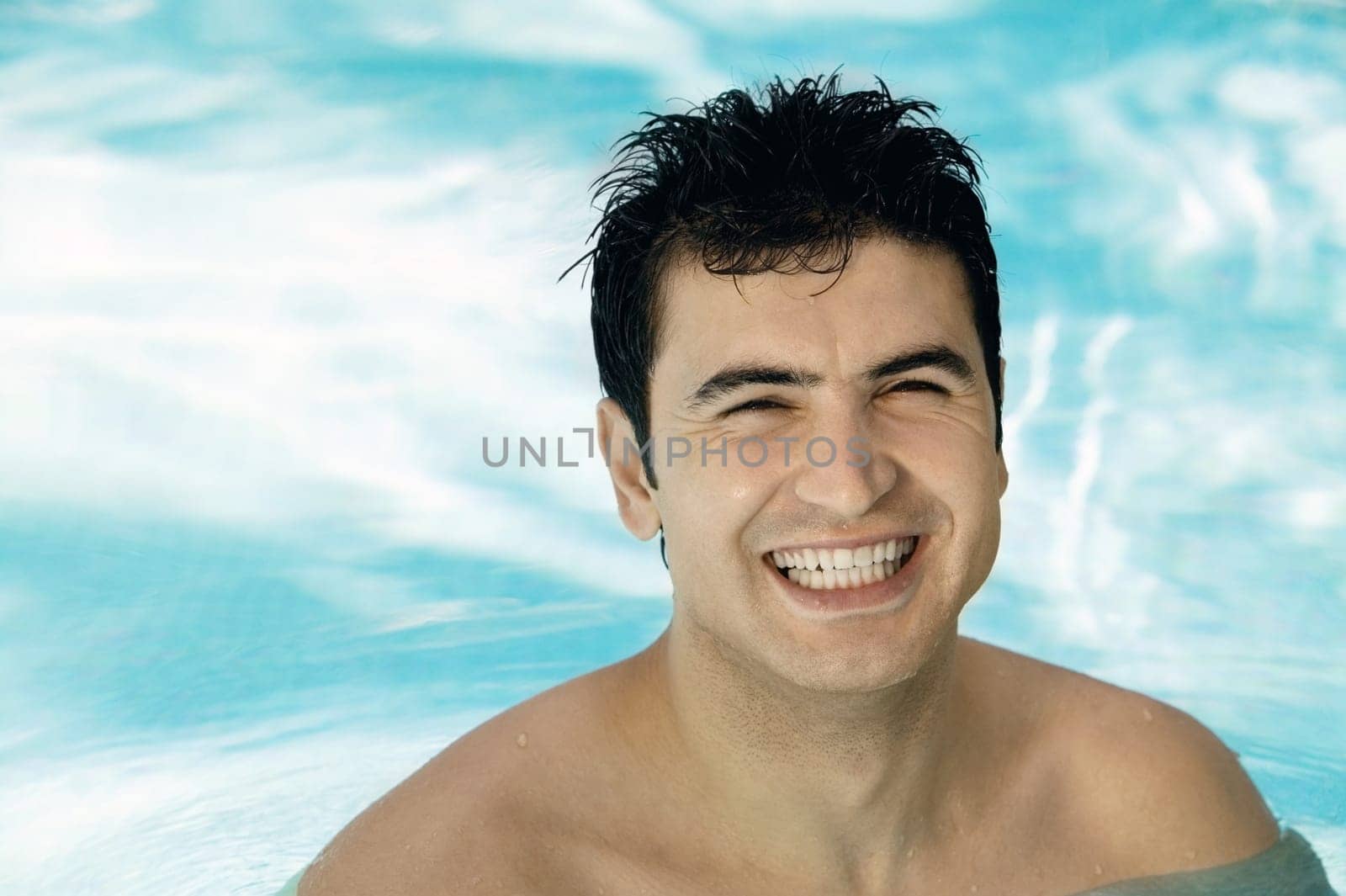 Portrait of a young man smiling in a swimming pool