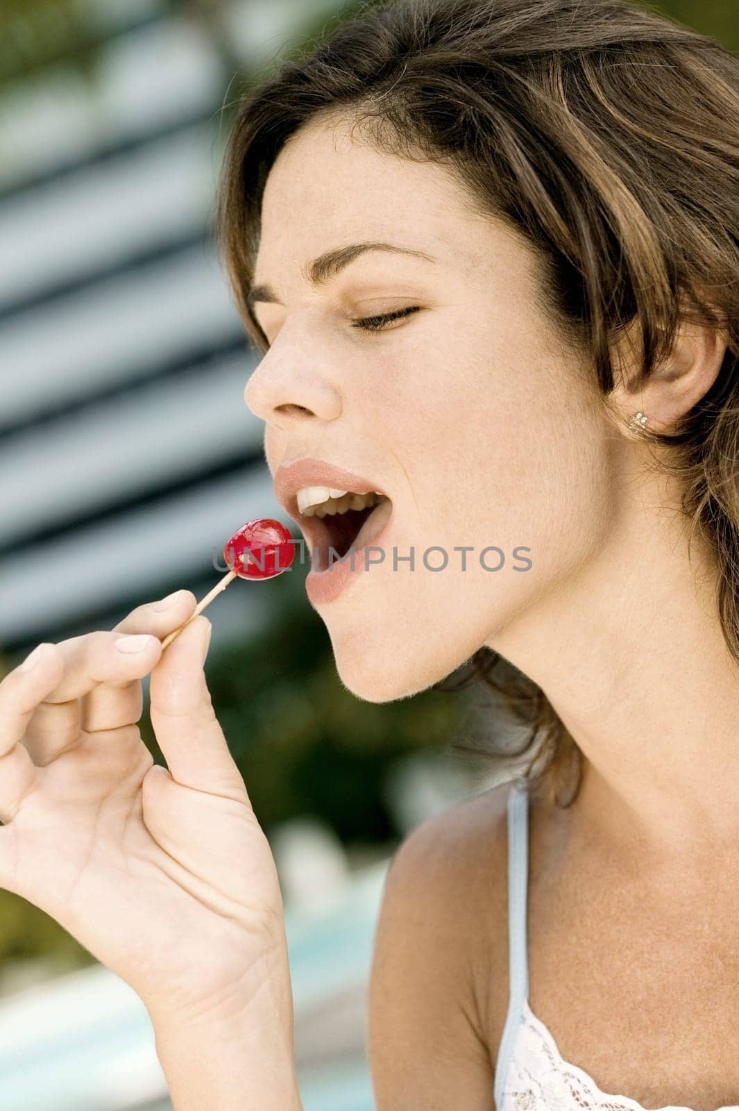 Close-up of a young woman eating a cherry