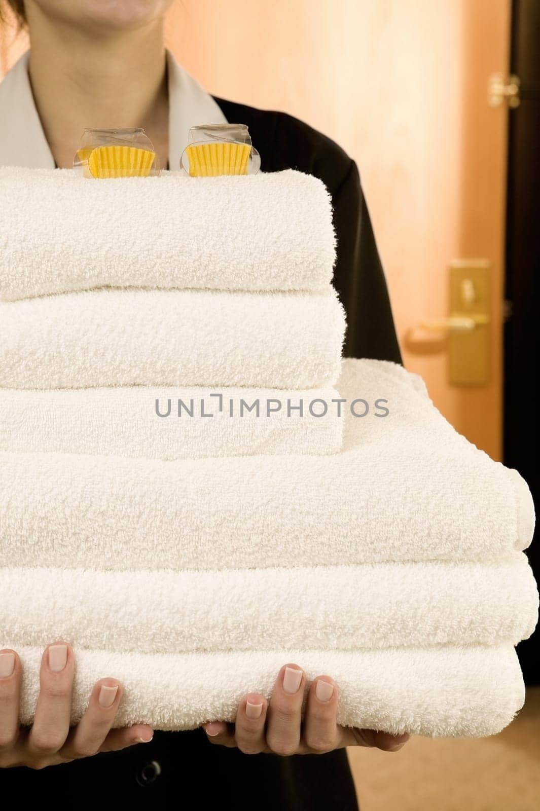 Mid section view of a waitress holding a stack of towels