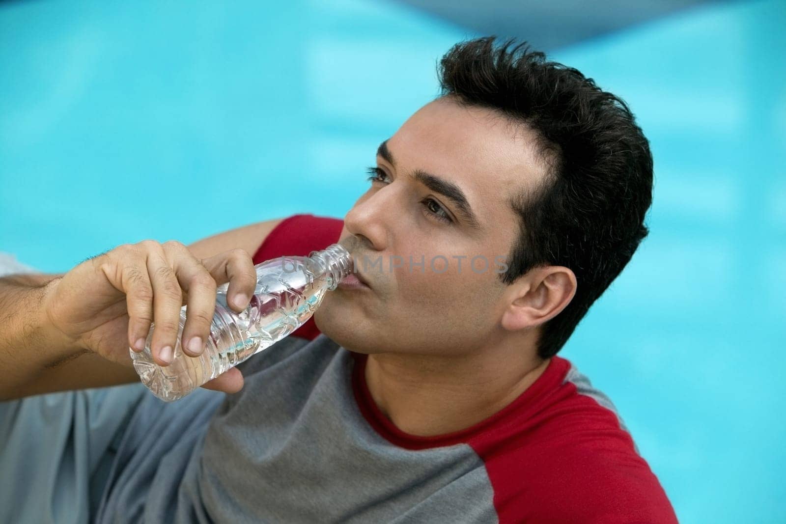 Close-up of a young man drinking water from a water bottle