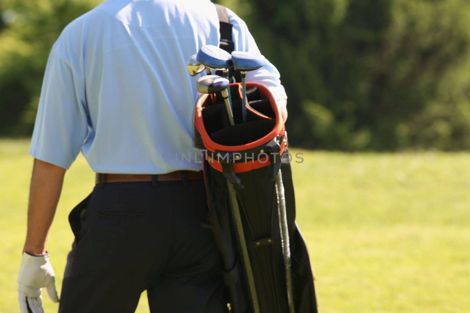 Mid section view of a man carrying a golf bag