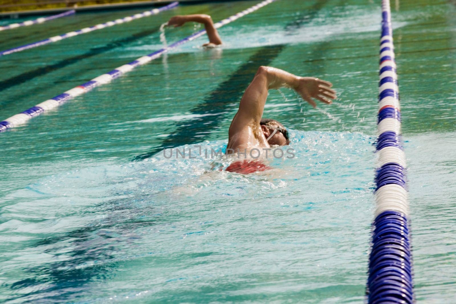 Side profile of a mid adult man swimming in a swimming pool