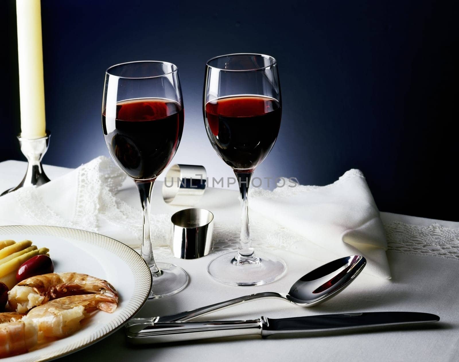 Two glasses of wine beside a plate of prawns