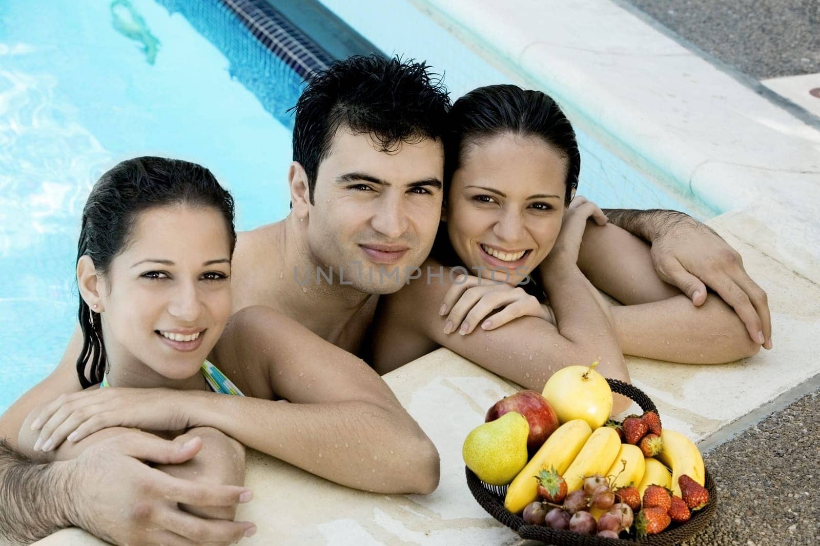 Portrait of two young women and a young man in a swimming pool