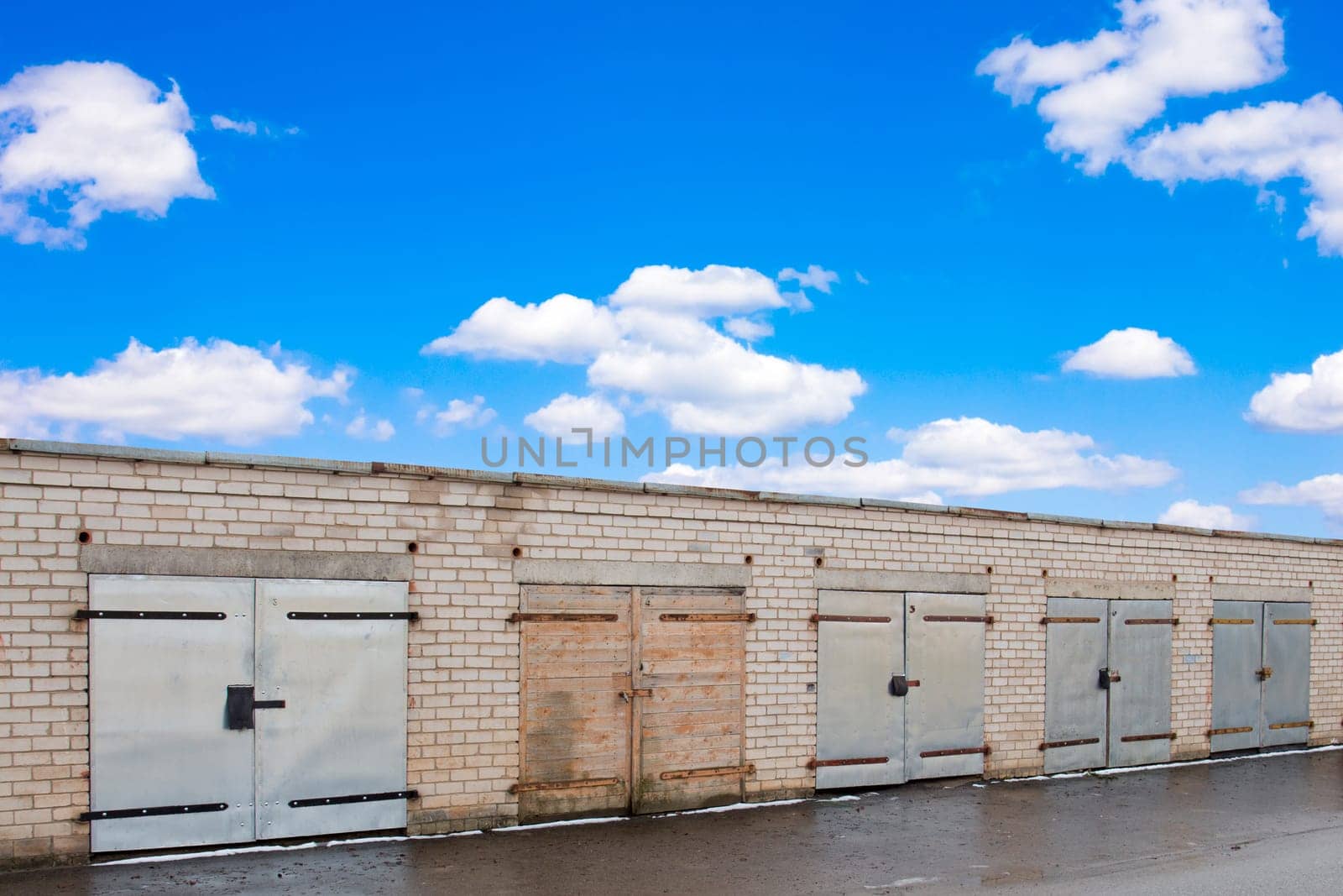 Row of garage doors under a blue sky