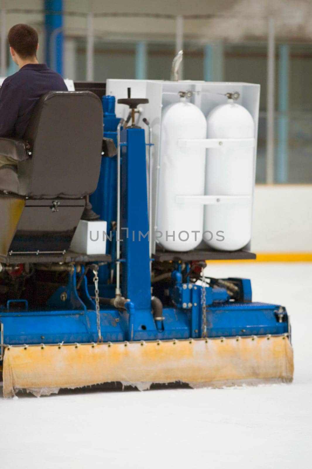 Rear view of a person sitting on an ice resurfacing machine