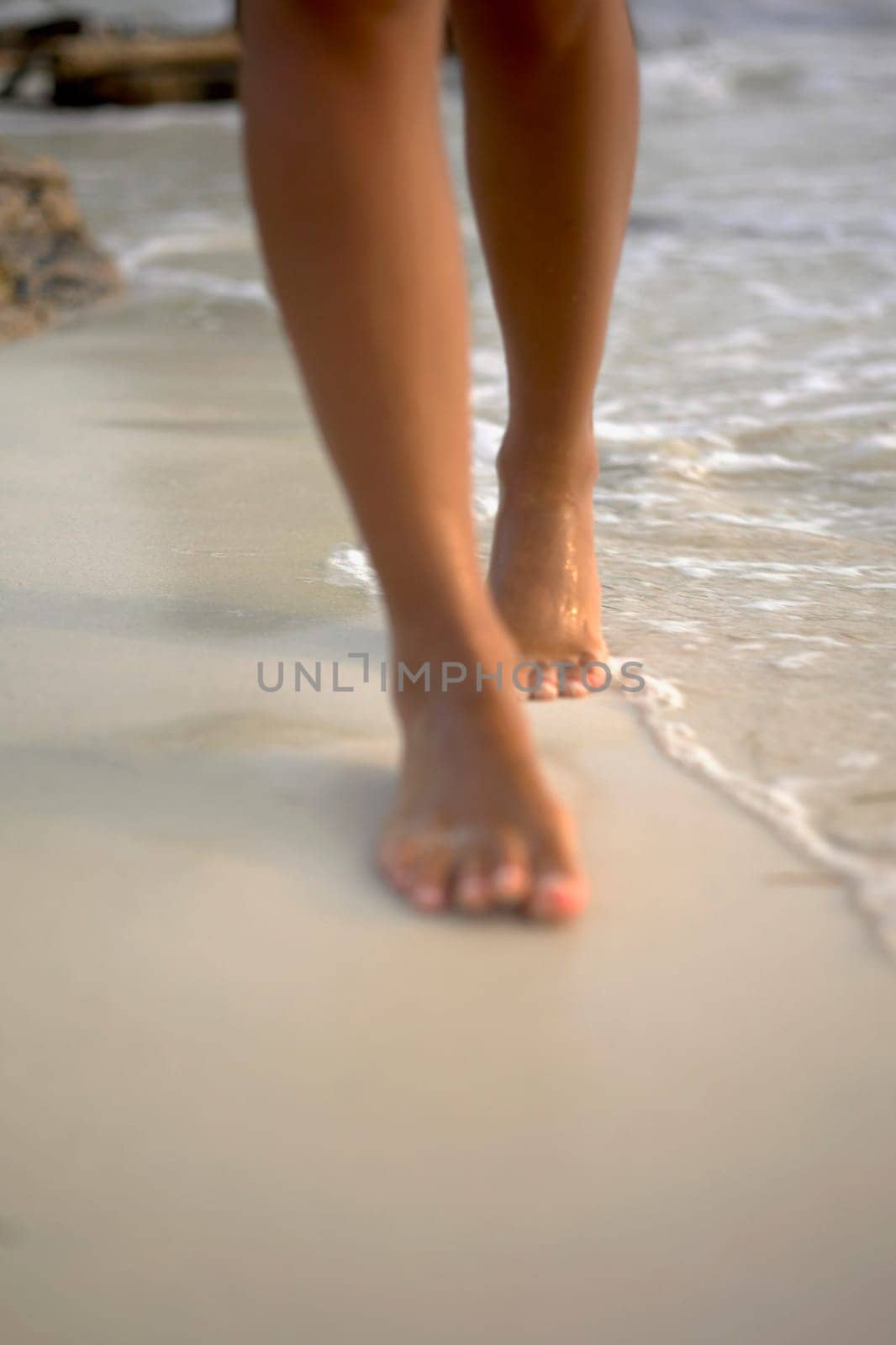 Low section view of a woman walking on the beach
