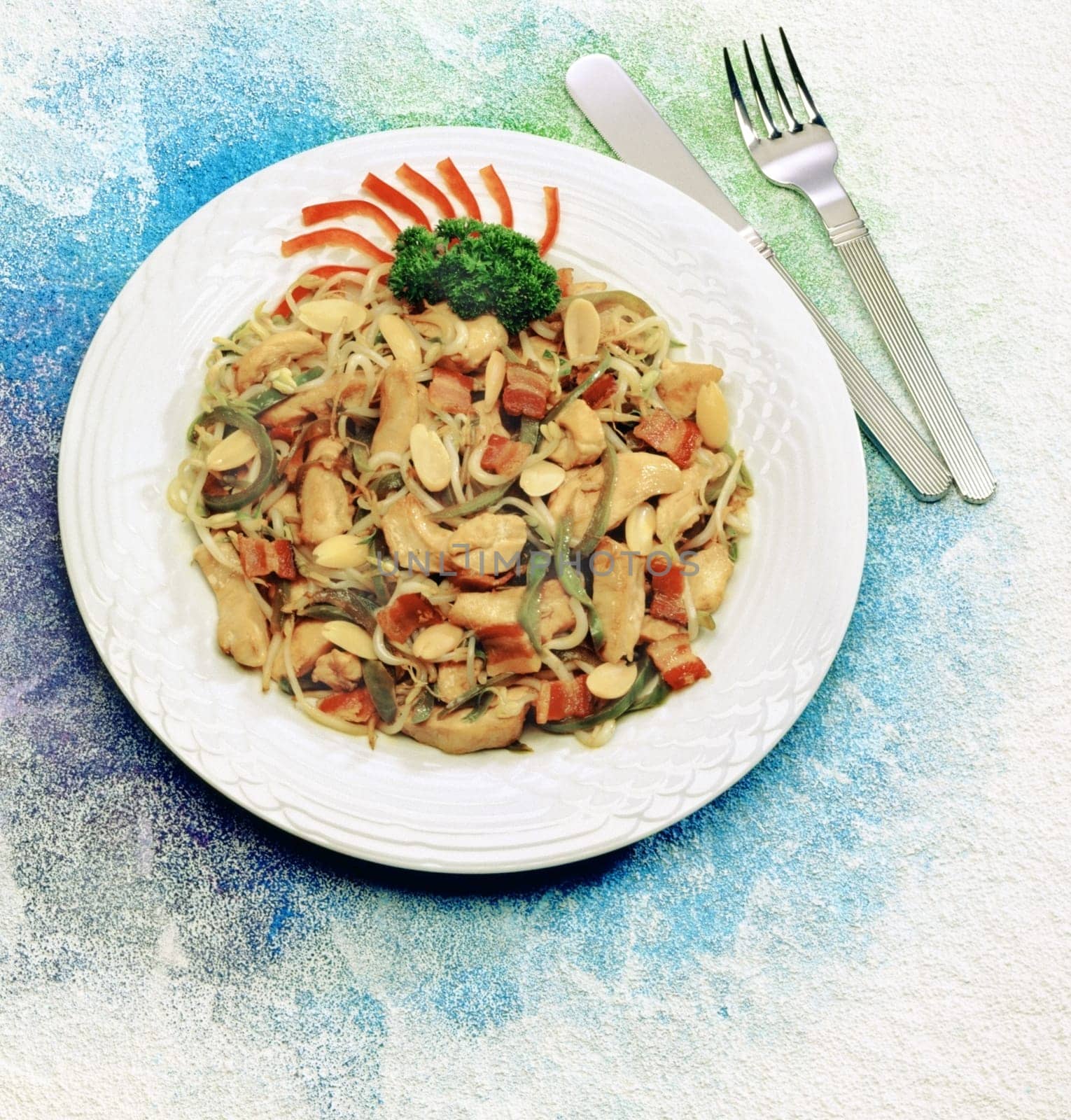 Close-up of noodles in a plate with fork and a knife