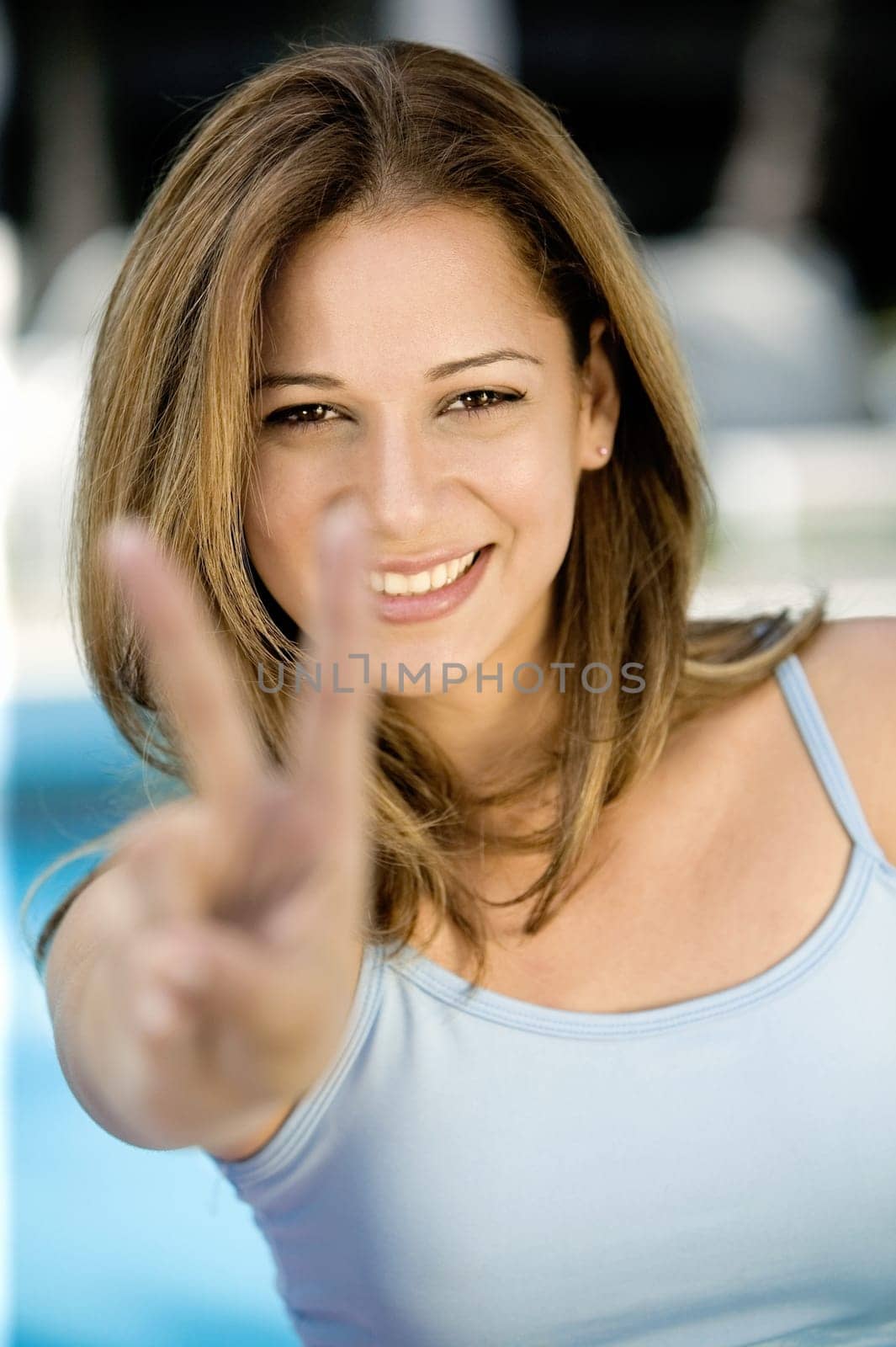Portrait of a young woman showing a peace sign
