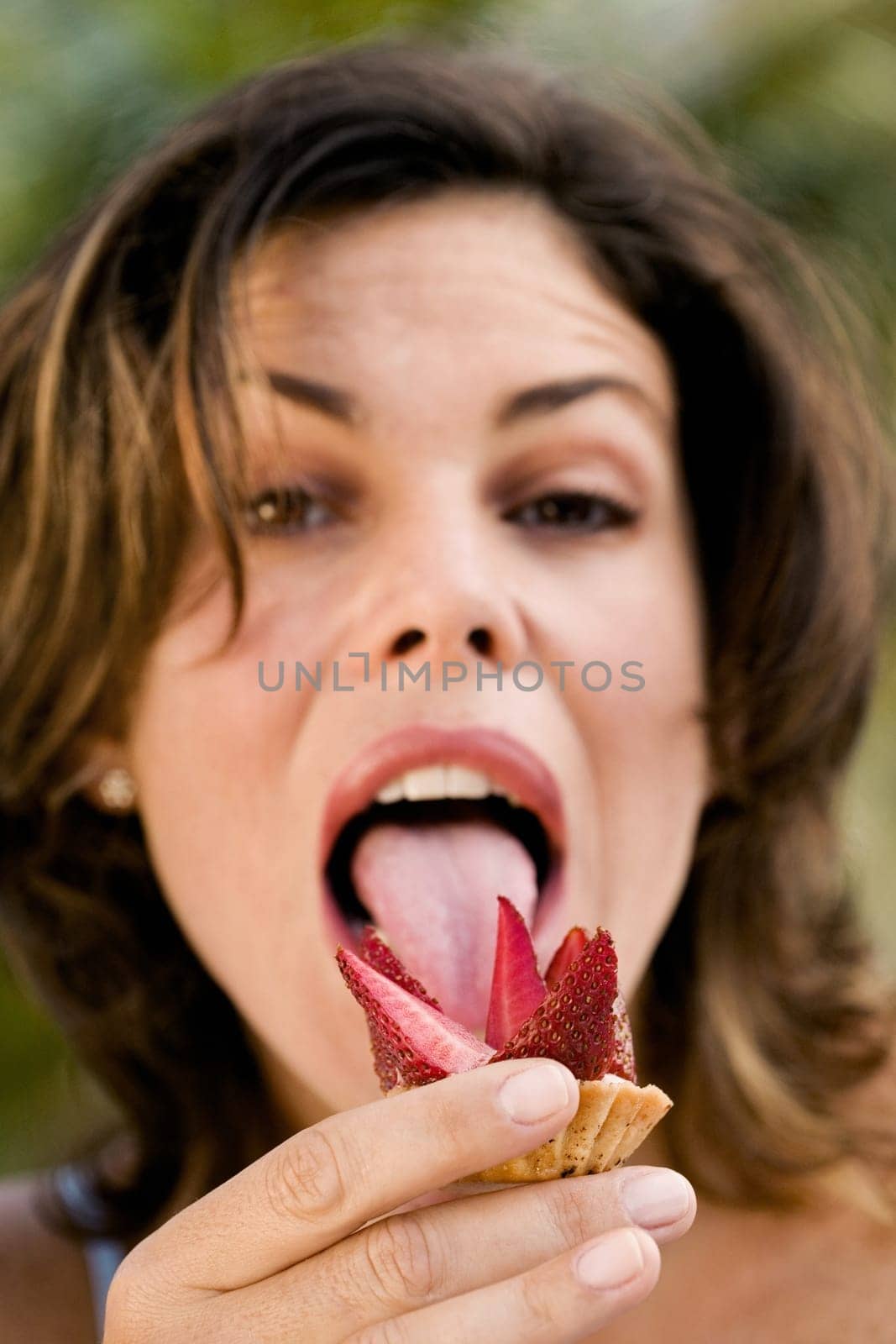 Portrait of a young woman eating a cupcake