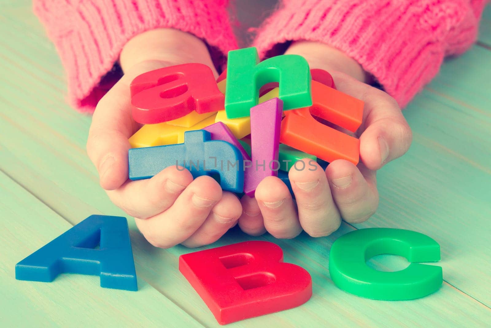 Child learning to read using magnetic letters. Education School Knowledge Concept