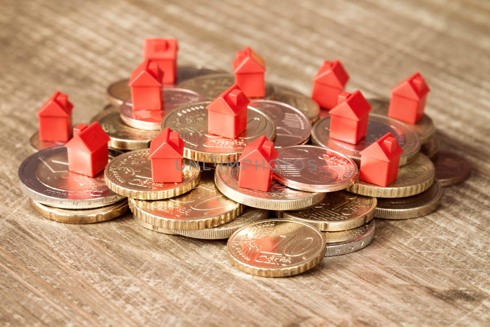 Mini houses resting on coins pile. Concept for property ladder, mortgage and real estate investment