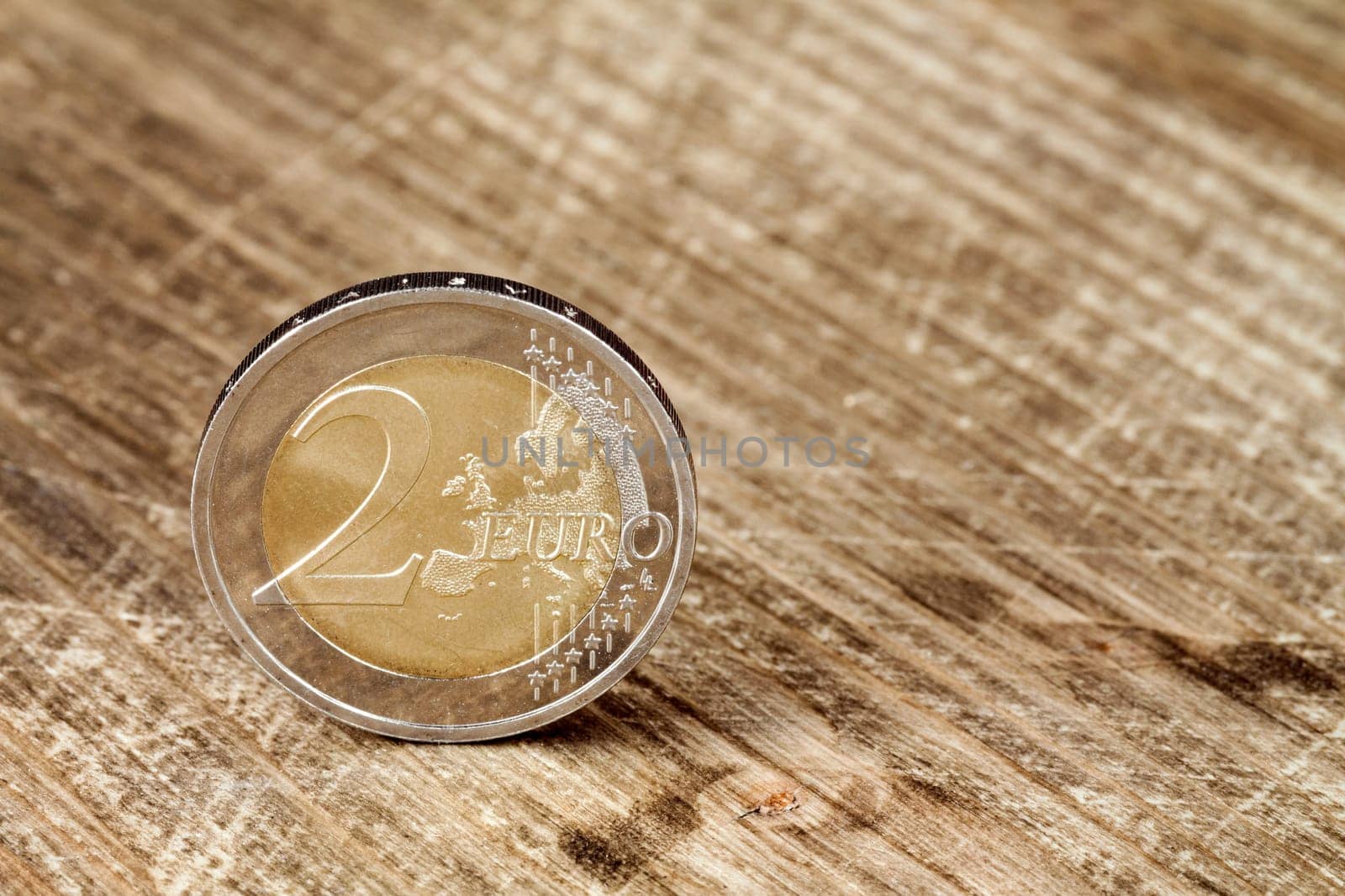 Two Euro coin on the wooden table surface
