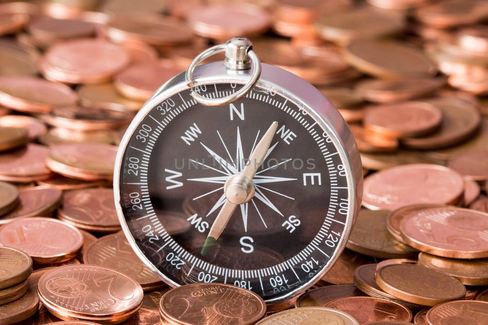 Pile of euro cent coins with a compass.Concept for financial direction