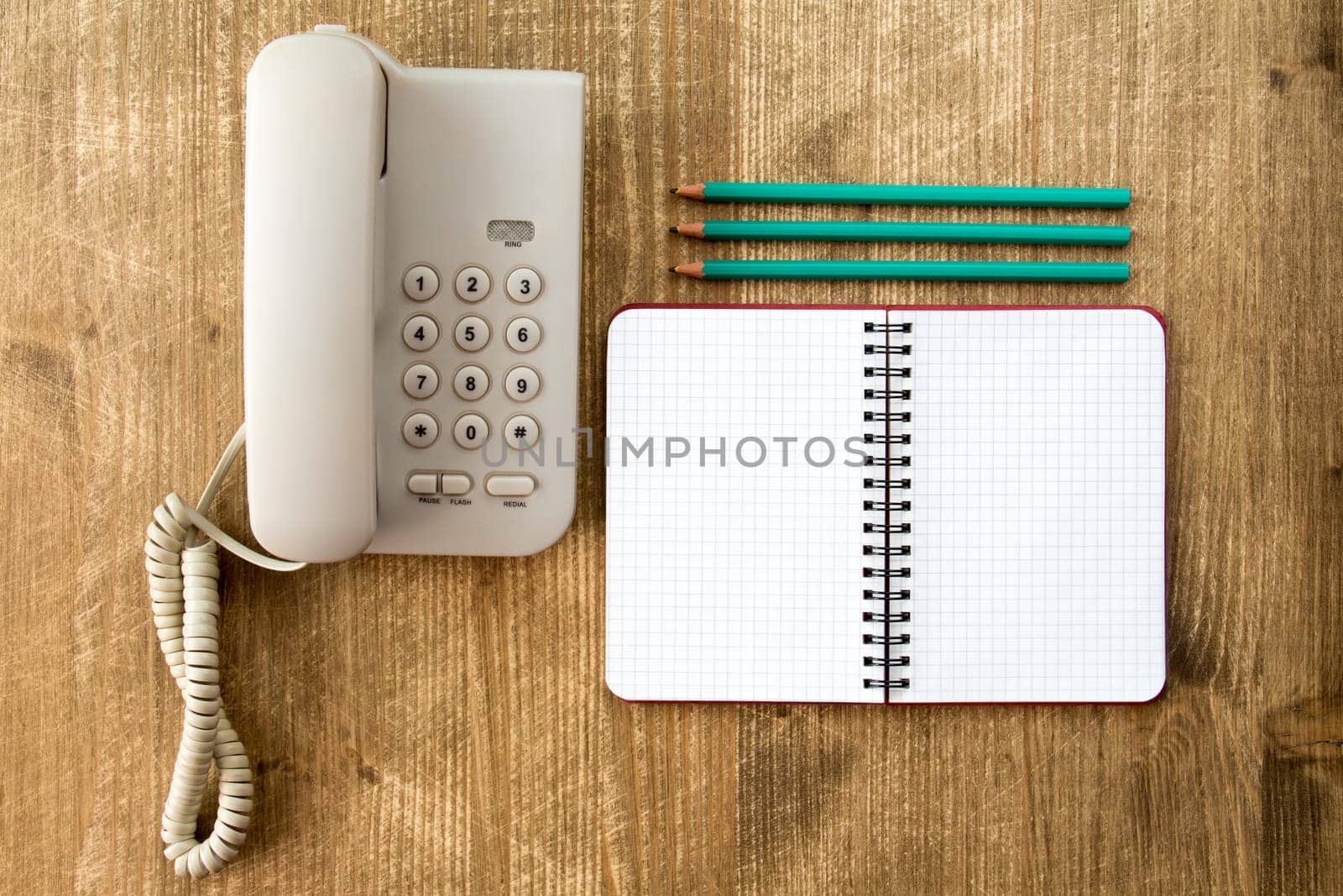 Touch tone telephone,blank notebook and three pencils