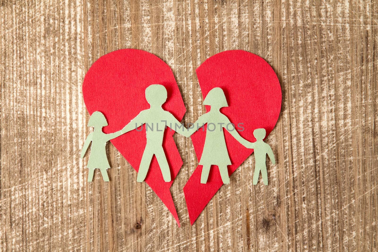 Paper family with broken heart on wooden table , divorce concept