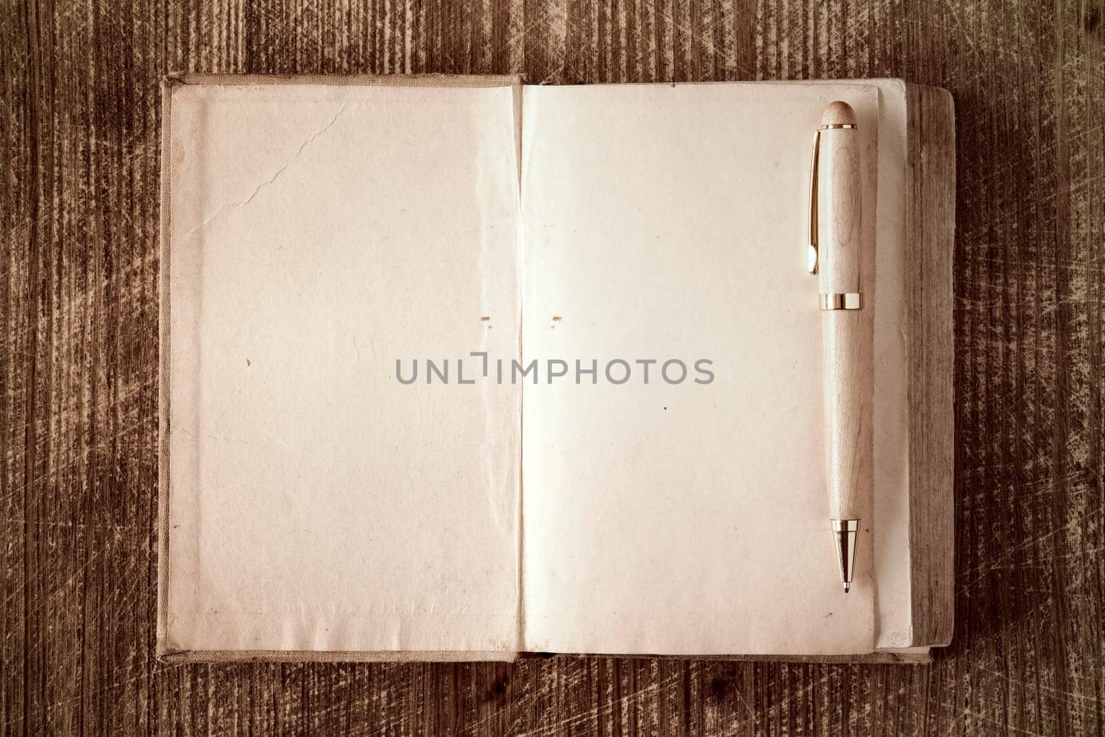 Closeup of open book and pen on wooden background