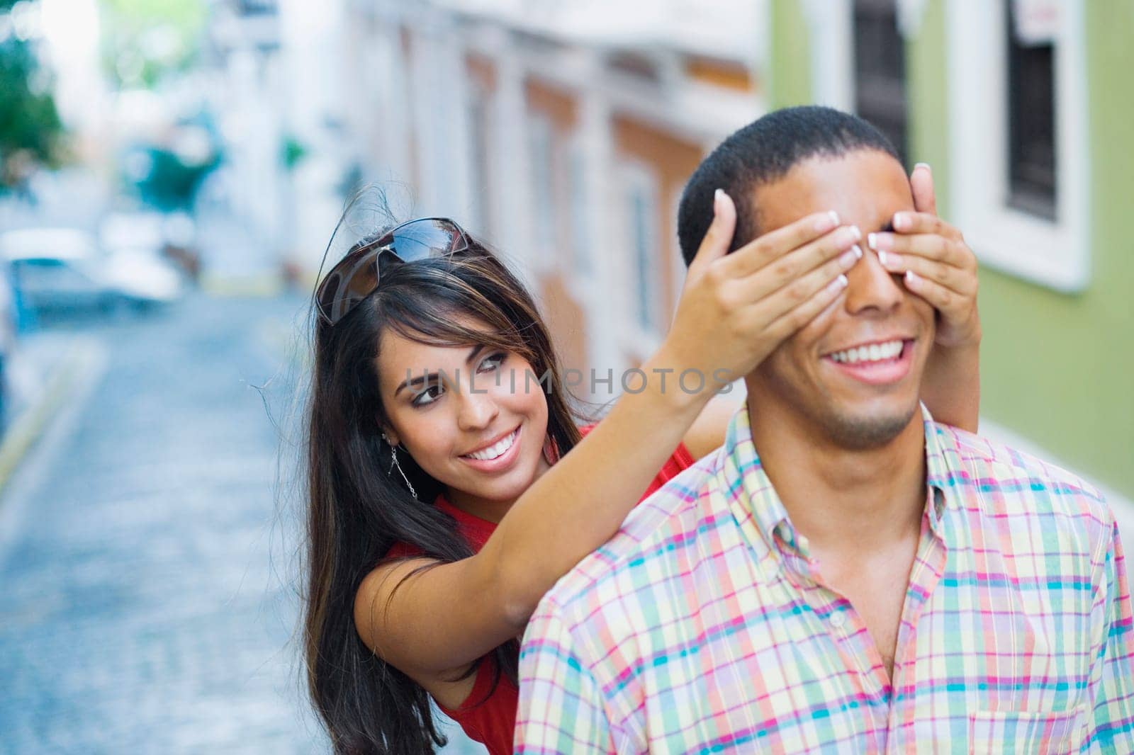 Close-up of a teenage girl covering a young manŽs eyes from behind