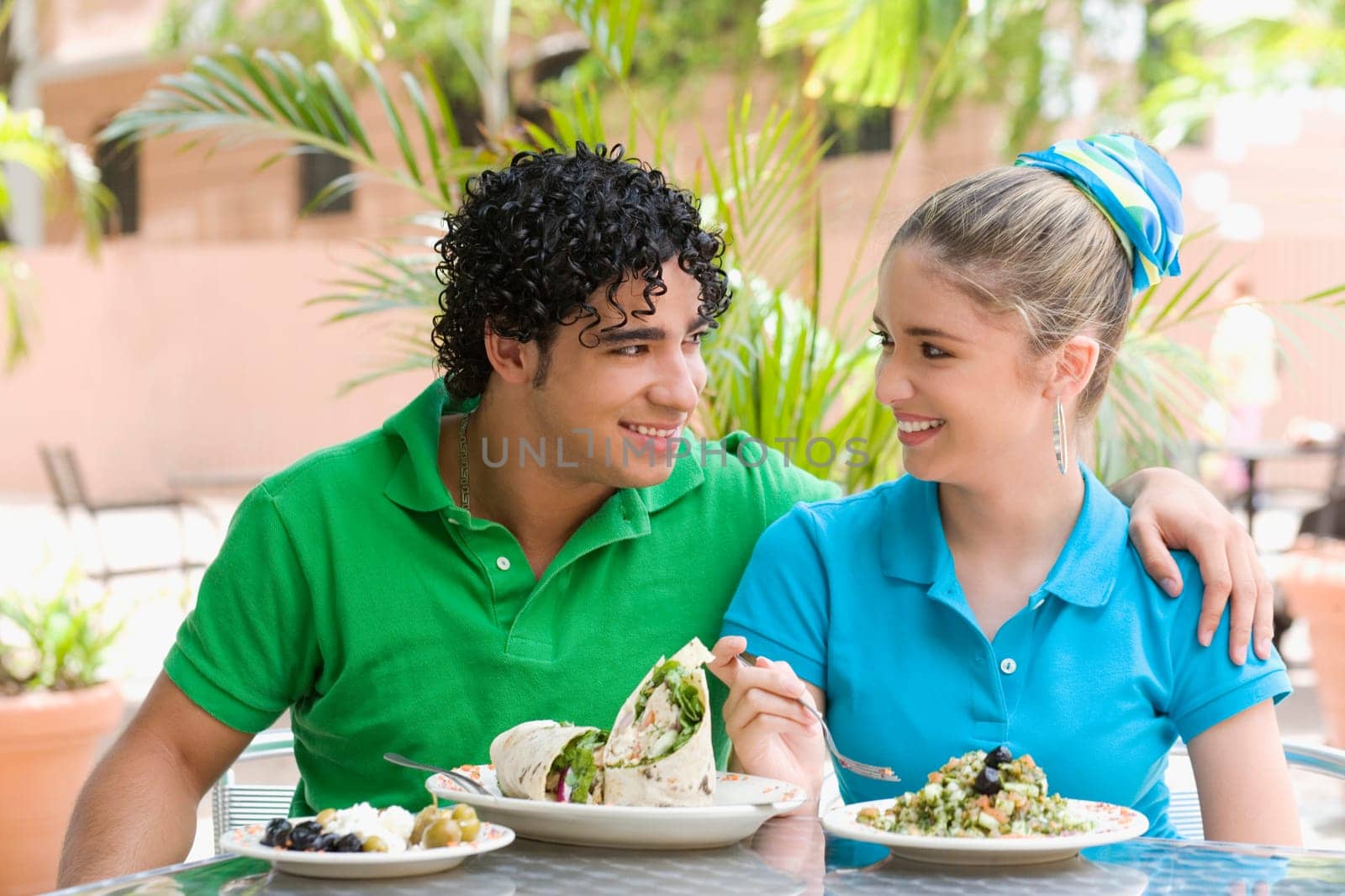 Close-up of a young man and a teenage girl sitting at a table in a restaurant