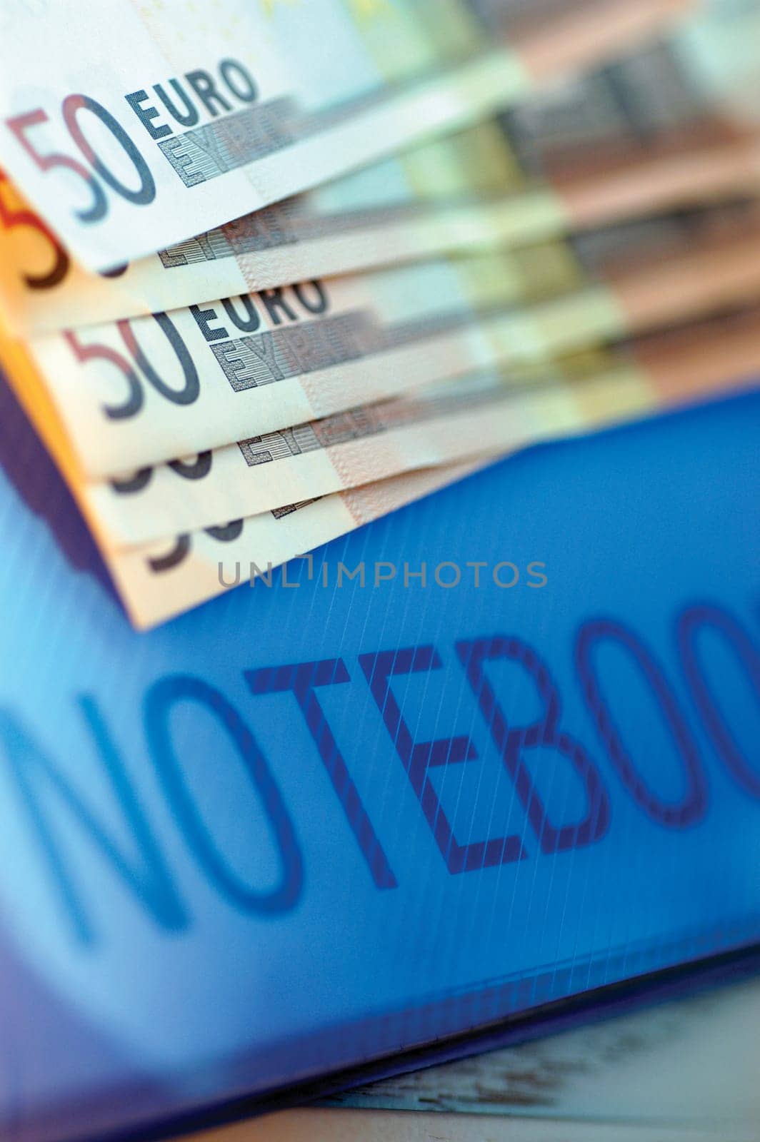 Close-up of five hundred Euro banknotes on a notebook