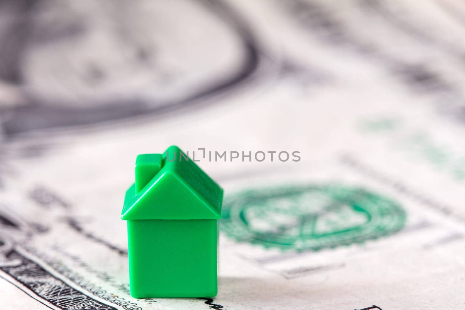 Miniature house on dollar banknote background. Concept for property ladder, mortgage and real estate investment