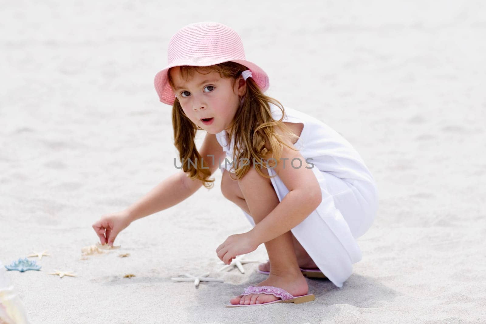 Portrait of a girl playing with a starfish on the beach