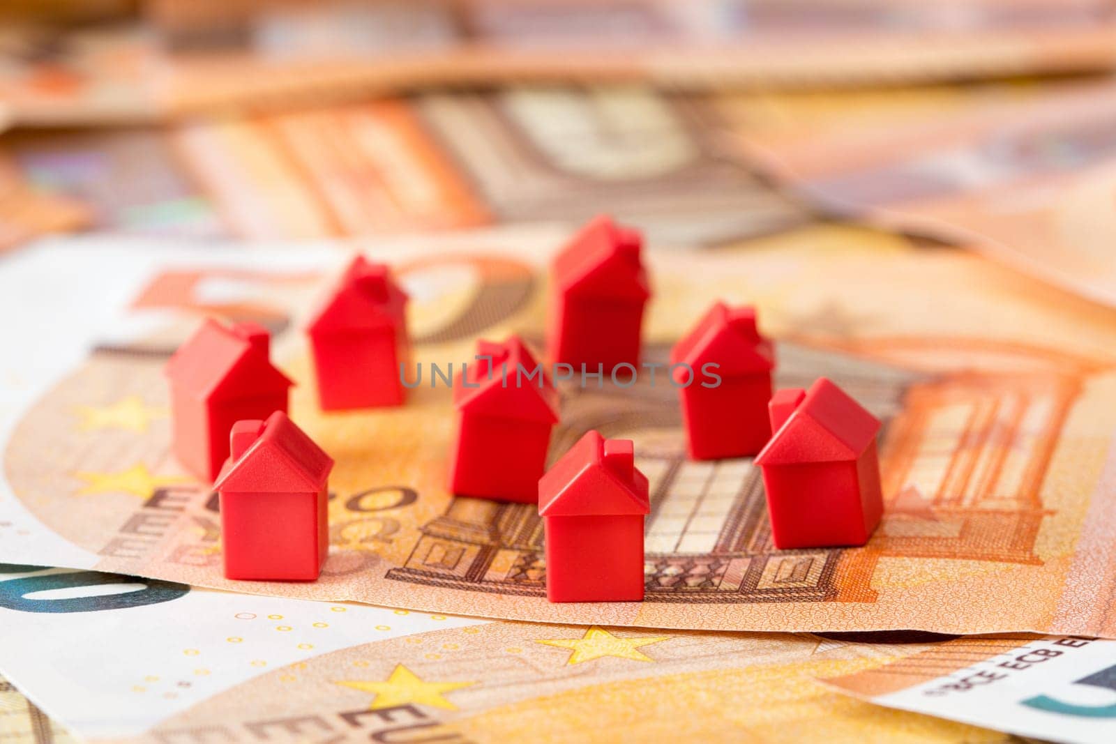 Miniature houses on Euro banknotes . Concept for property ladder, mortgage and real estate investment