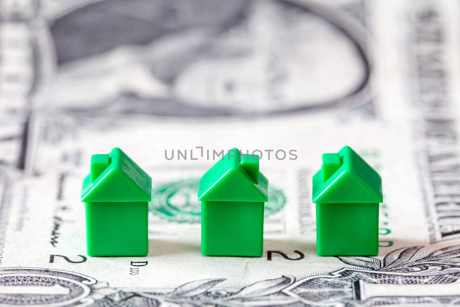 Miniature houses on dollar banknote background. Concept for property ladder, mortgage and real estate investment