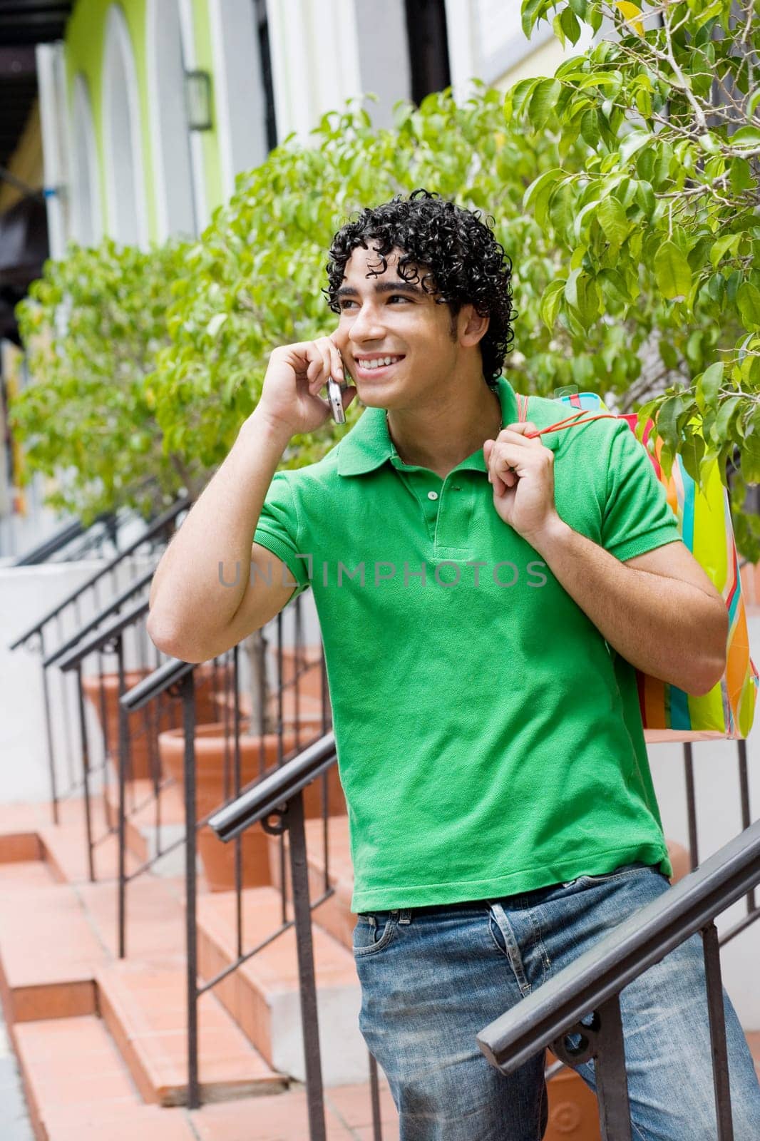 Young man using a mobile phone and smiling