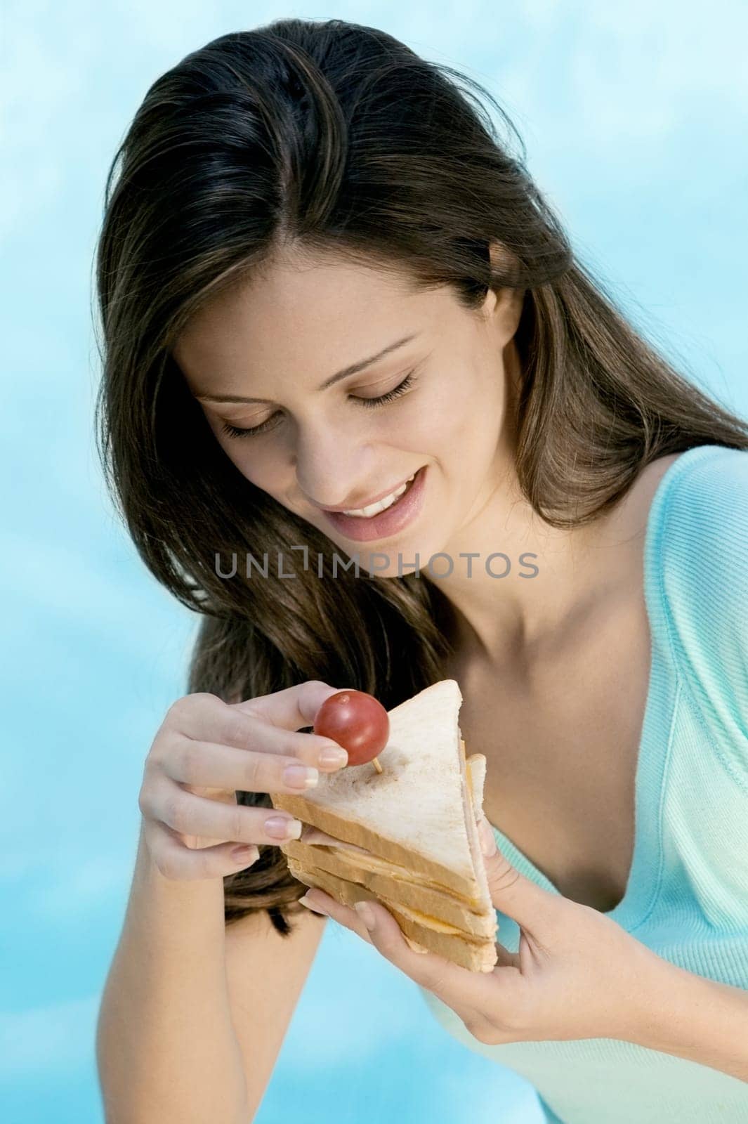 Close-up of a young woman holding a sandwich