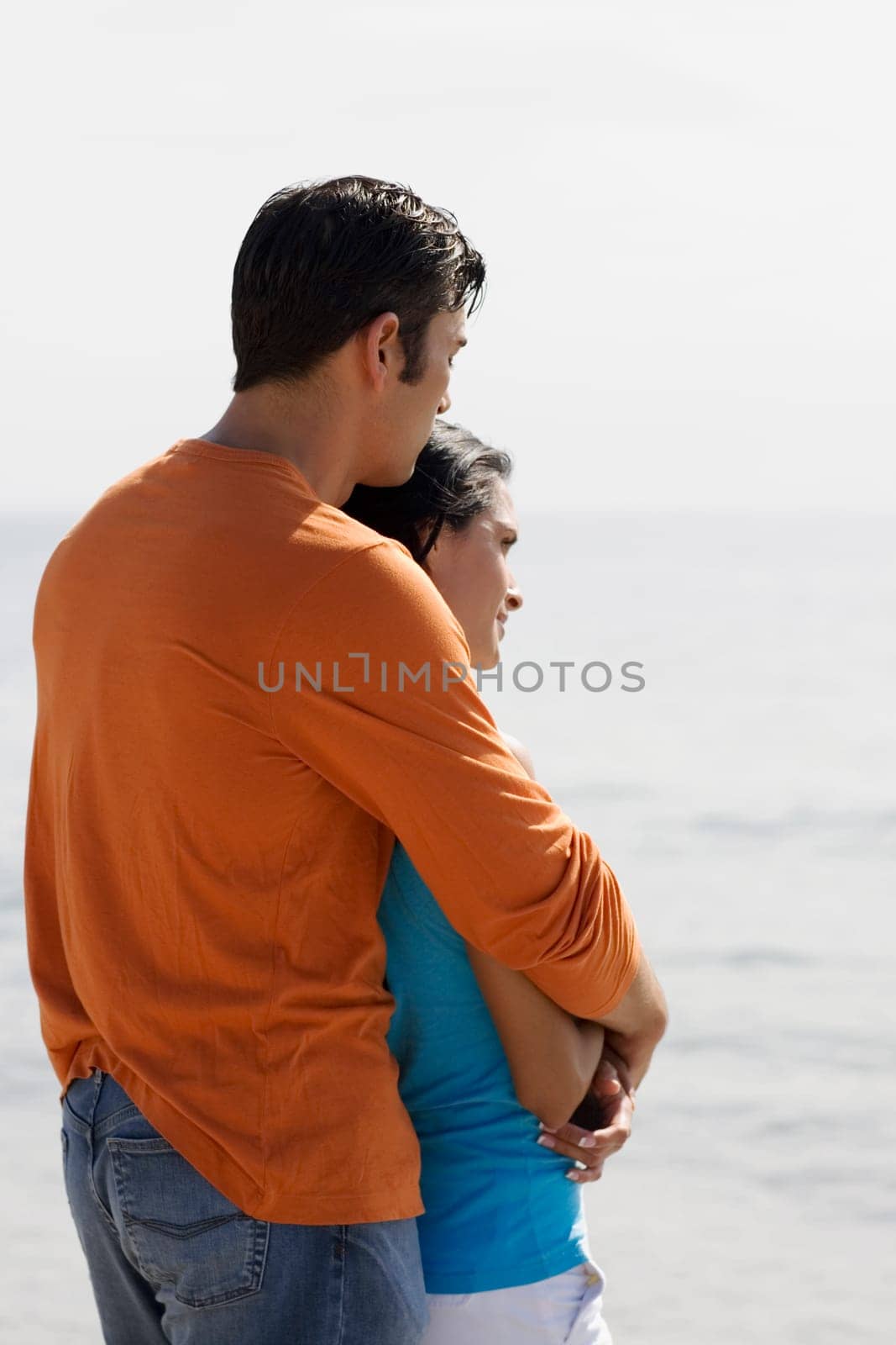 Side profile of a mid adult man embracing a young woman from behind