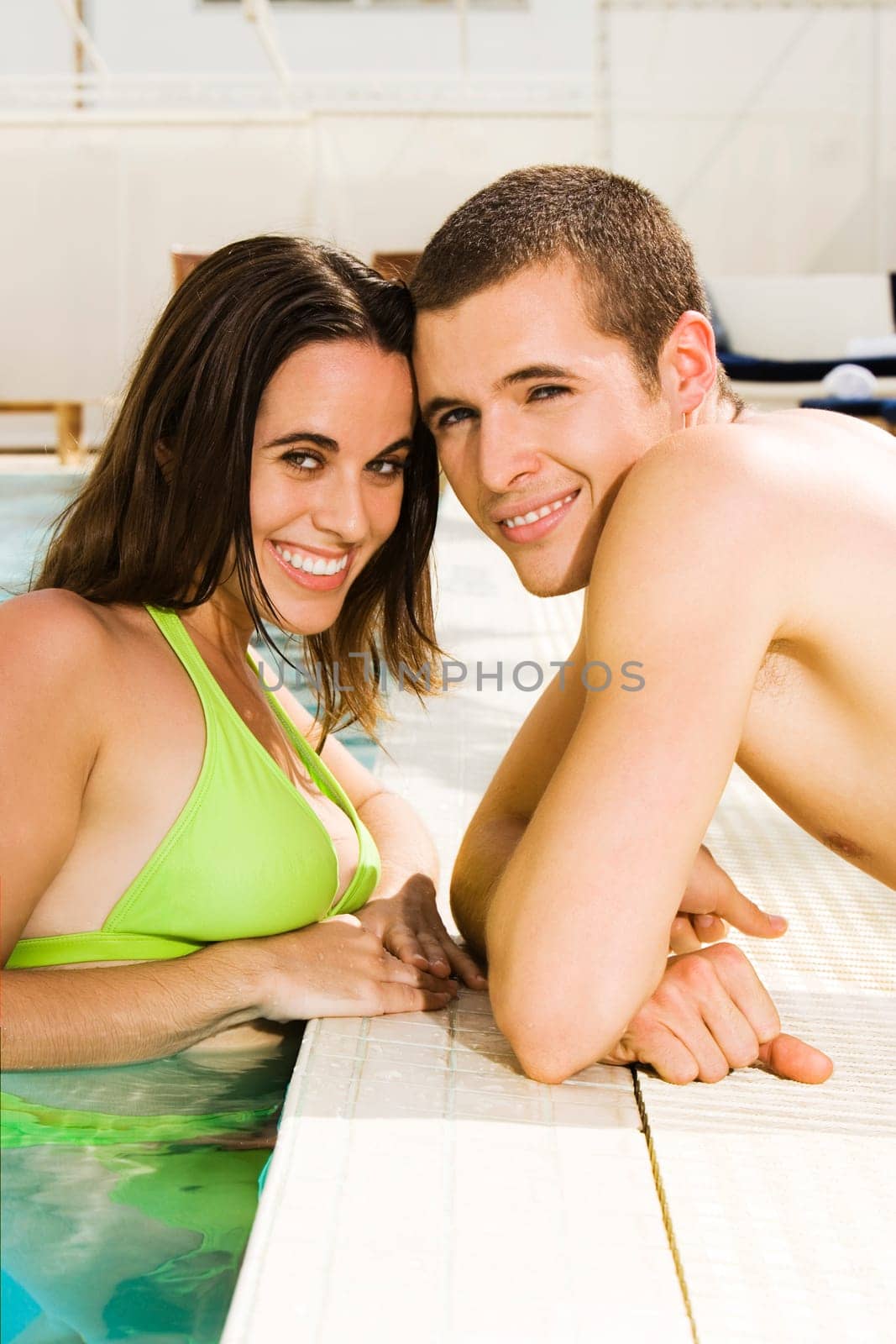 Portrait of a young couple smiling at the poolside