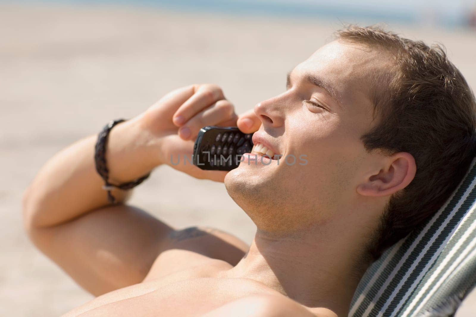 Side profile of a young man talking on a mobile phone