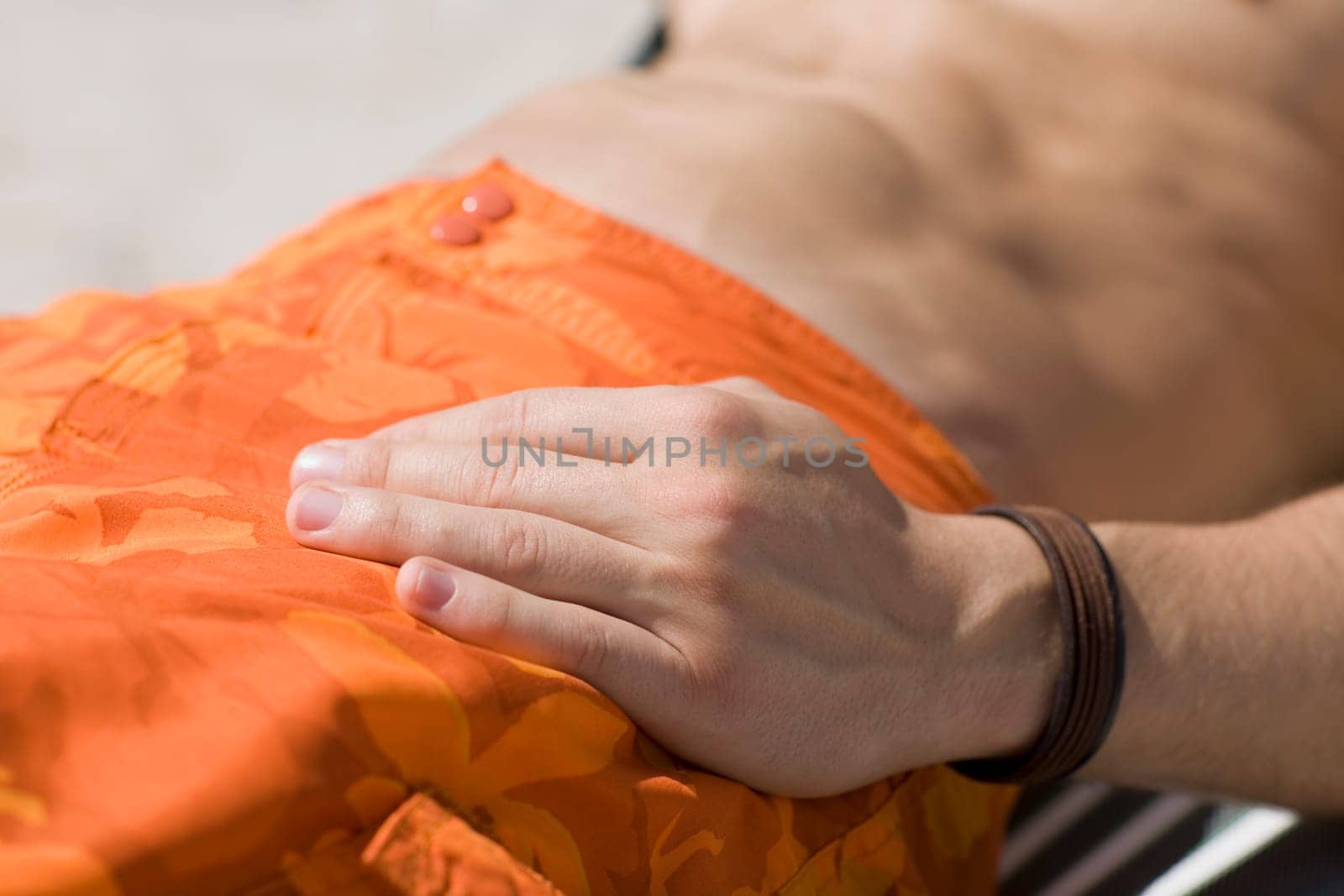 Mid section view of a man relaxing on a lounge chair