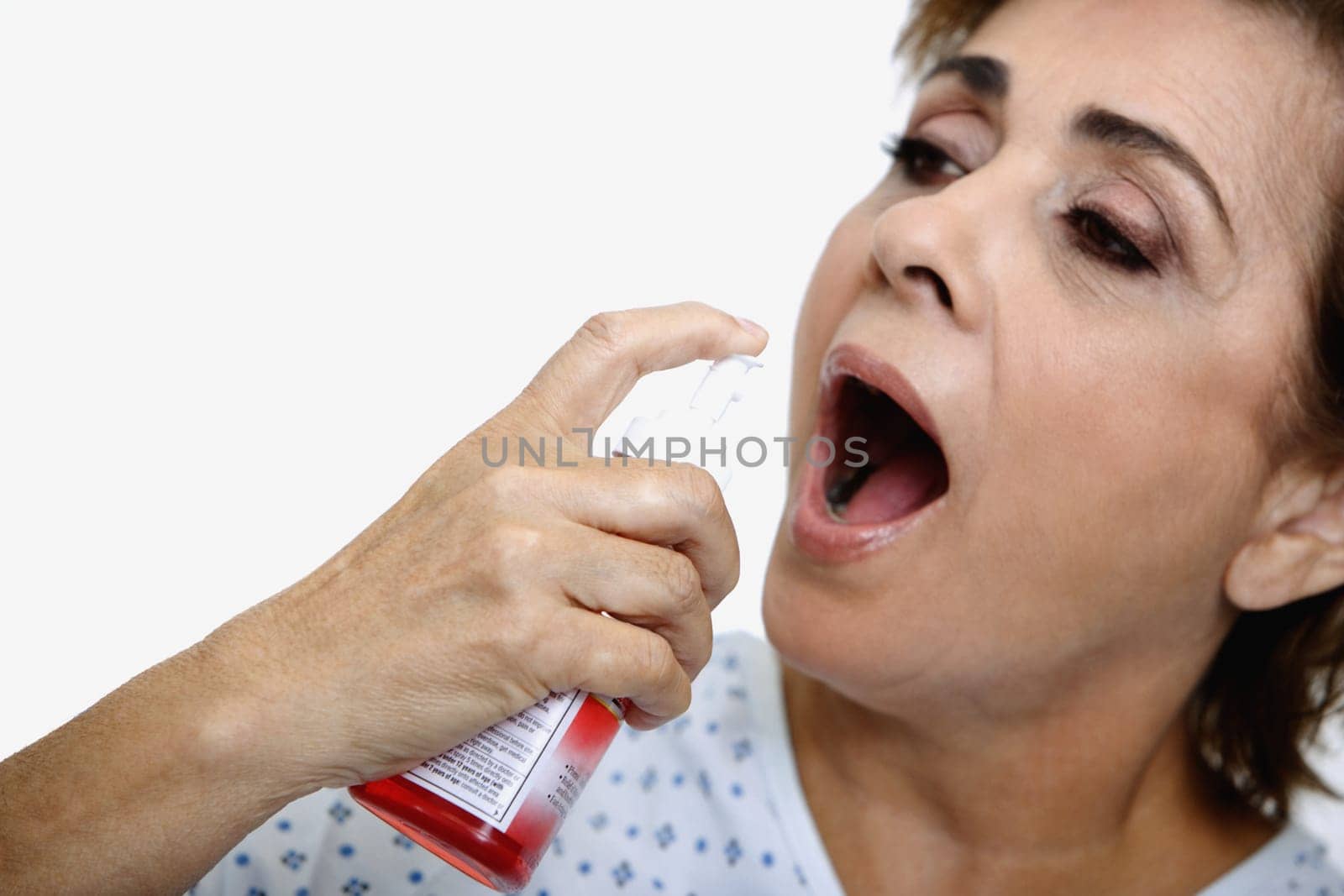 Close-up of a senior woman spraying mouthwash into her mouth