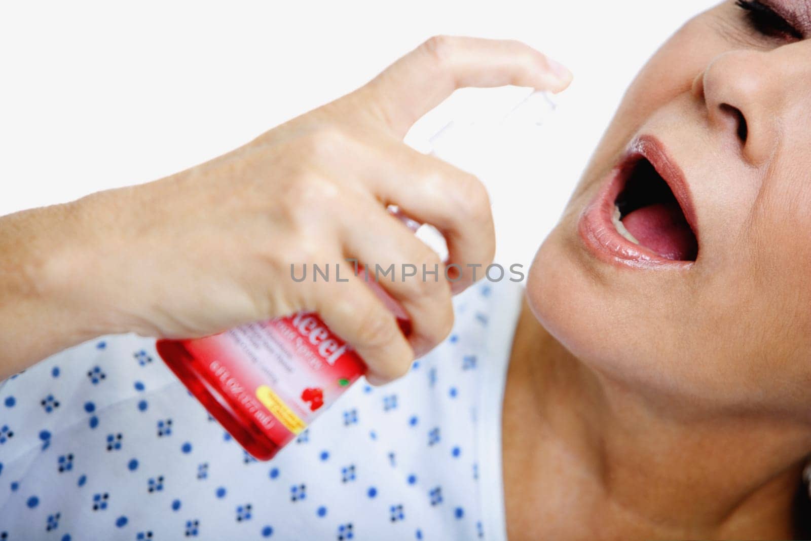Close-up of a senior woman spraying mouthwash into her mouth