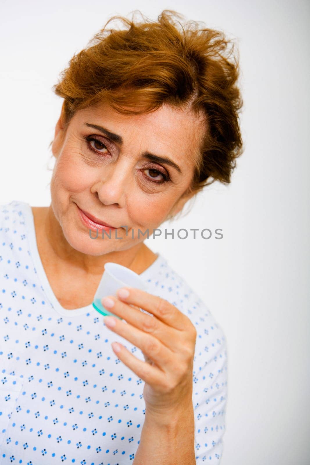 Portrait of a senior woman taking syrup from a measuring cup