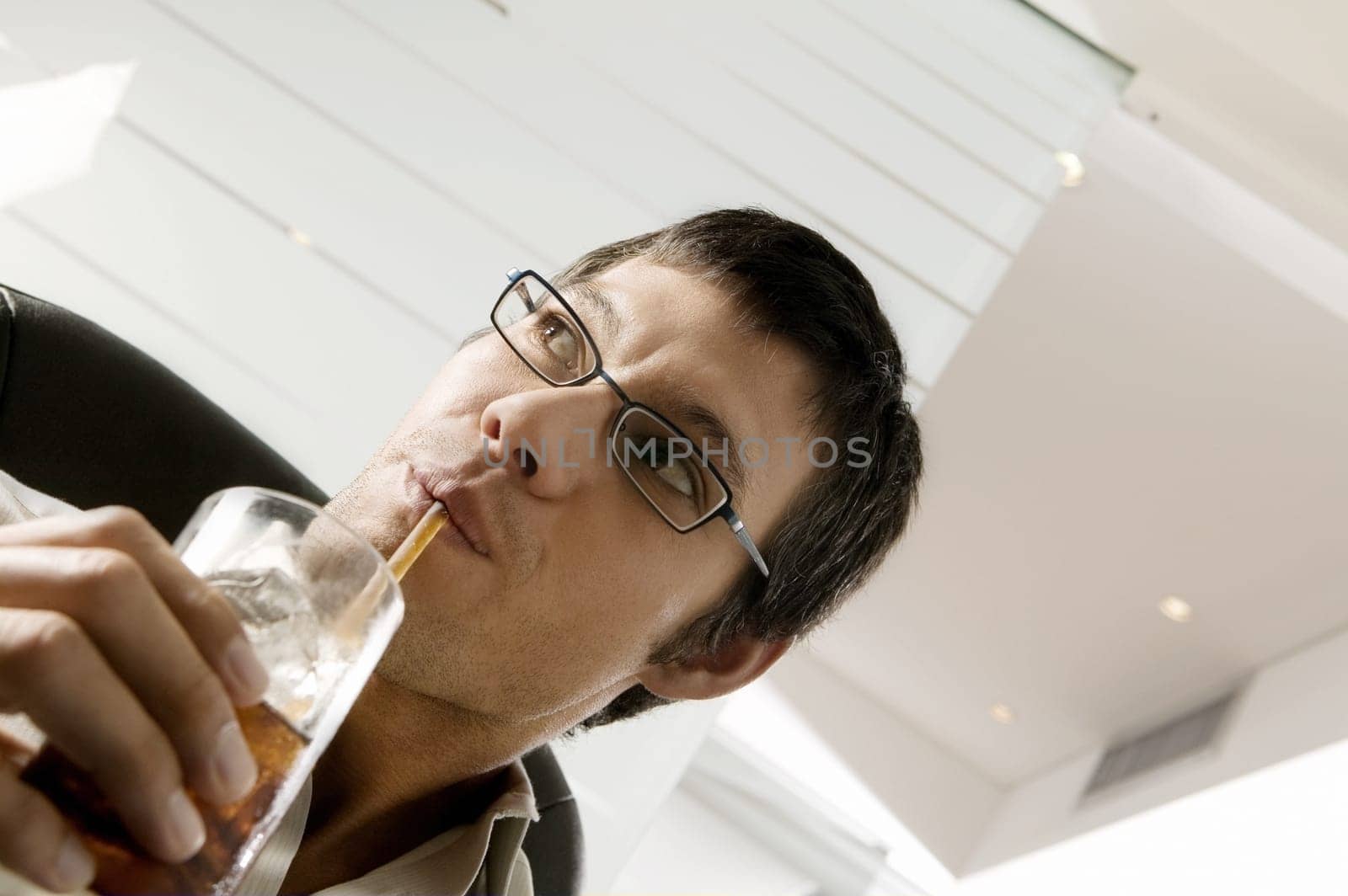Close-up of a businessman sipping a drink with a straw