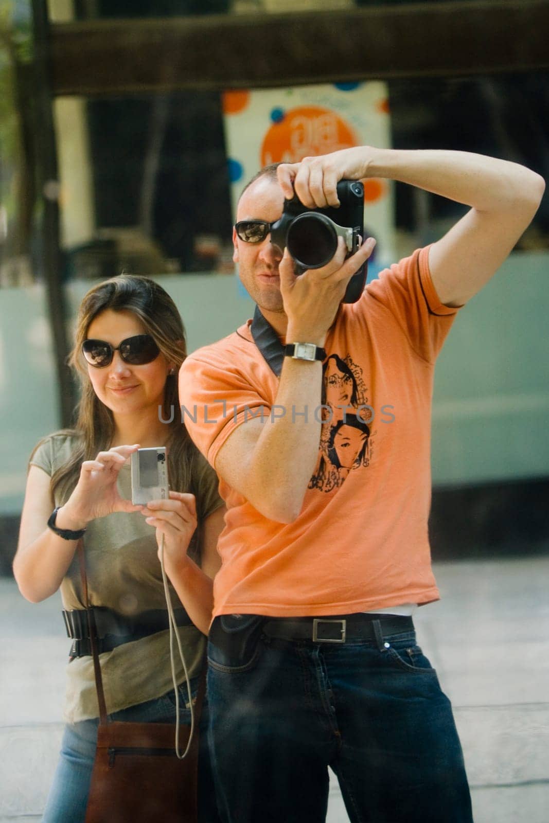 Mid adult man and a young woman taking photographs