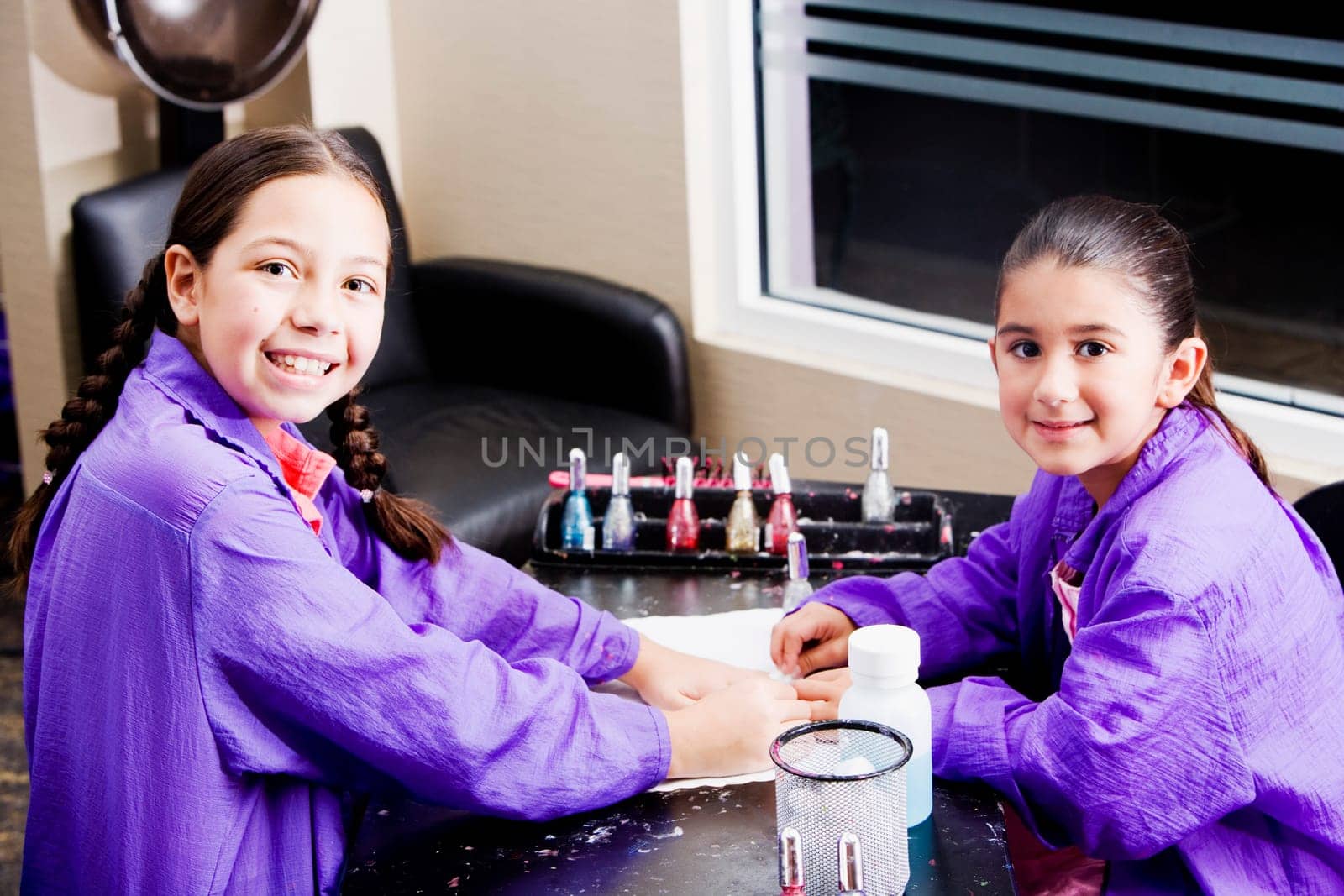 Portrait of a girl giving her sister a manicure