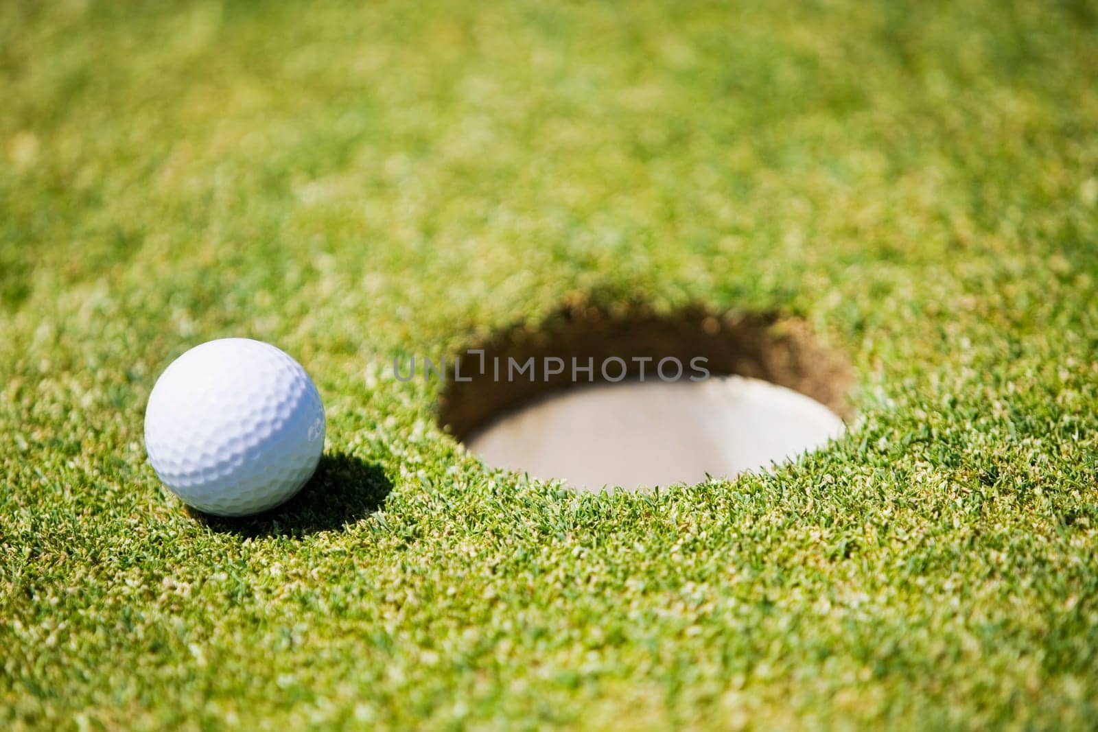 Golf ball at the edge of a hole