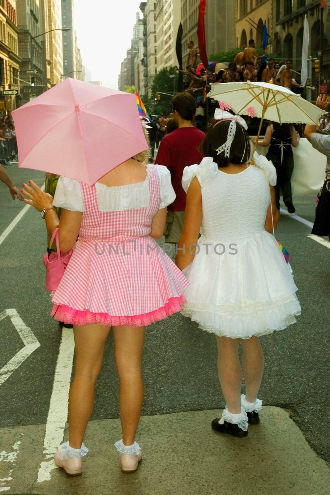 Rear view of two women standing on the road holding umbrellas