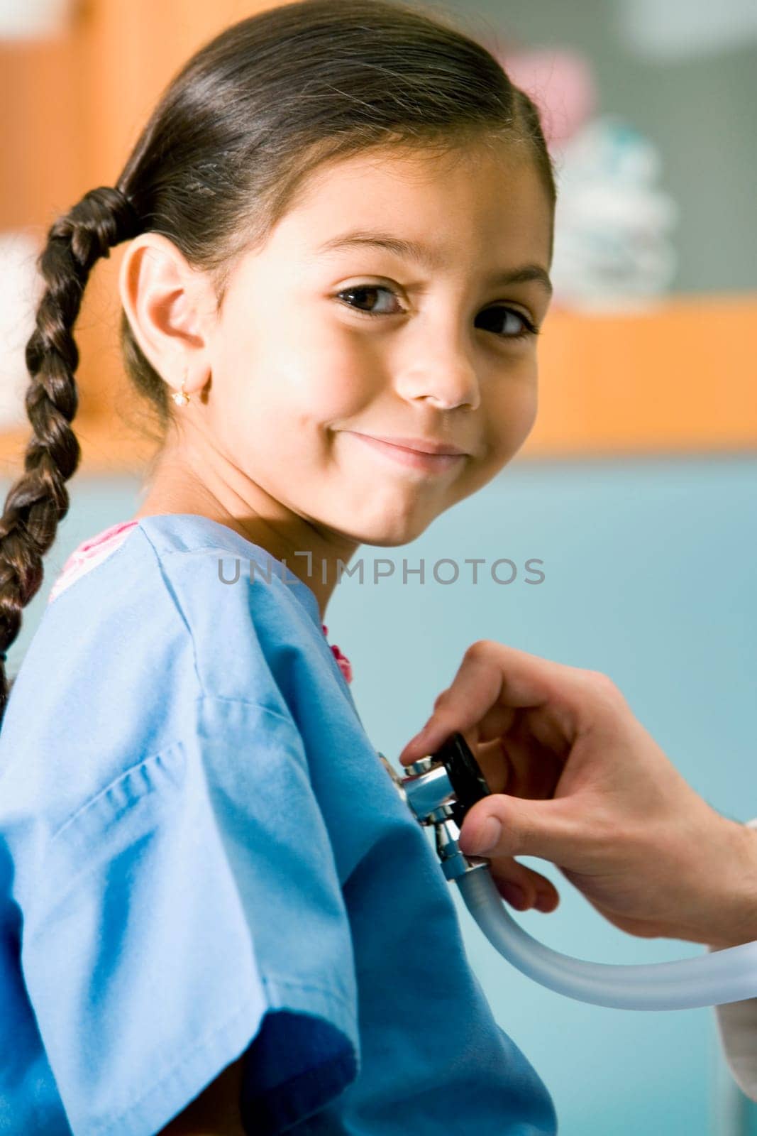 Portrait of a girl smirking while a doctor examining her