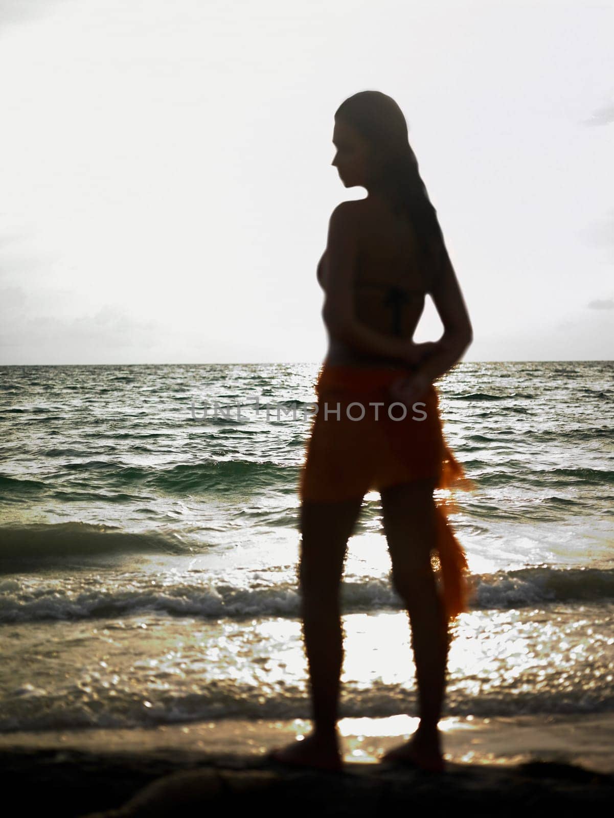 Side profile of a young woman standing on the beach