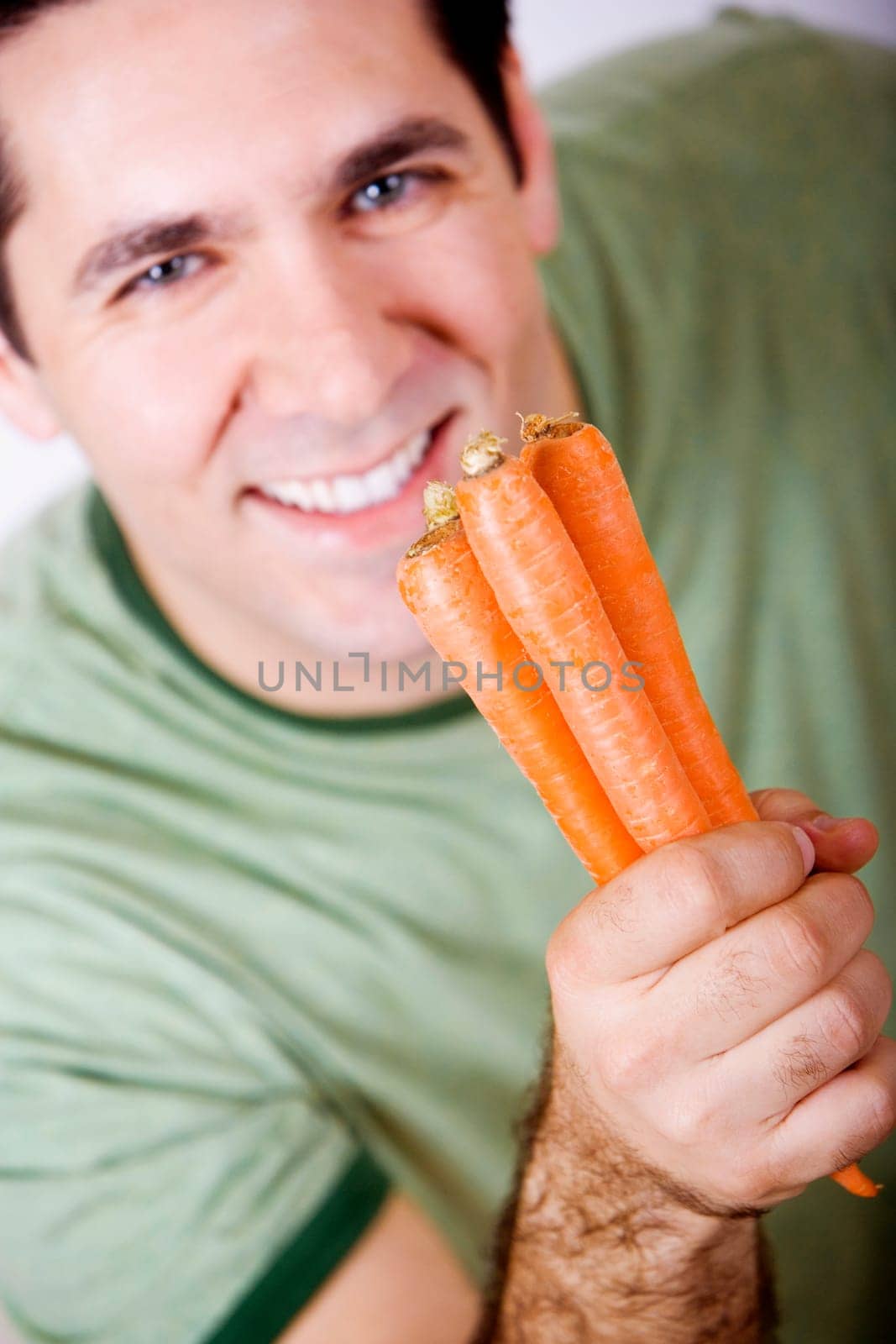 Portrait of a mid adult man holding carrots and smiling