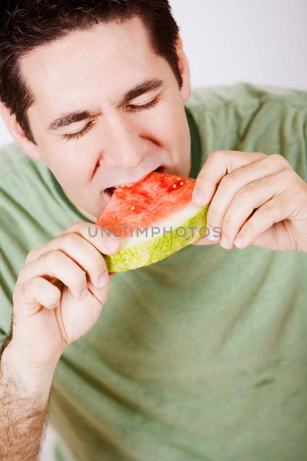 Close-up of a mid adult man eating a slice of watermelon