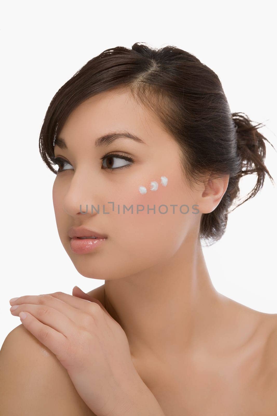 Three dots of moisturizer cream on a womanŽs face